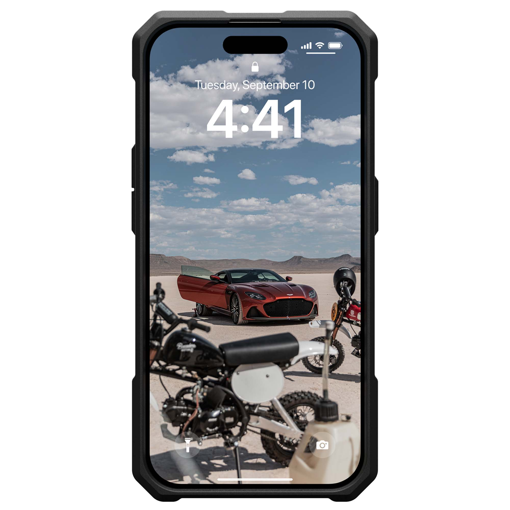 Smartphone mit einem Auto und zwei Motorrädern auf dem Bildschirm, in einer Wüstenlandschaft.