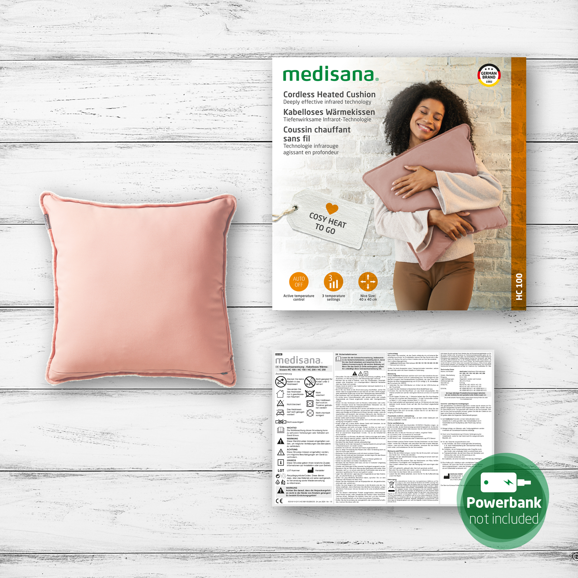Rosa beheiztes Kissen, Produktverpackung und Infoblatt auf Holzoberfläche.