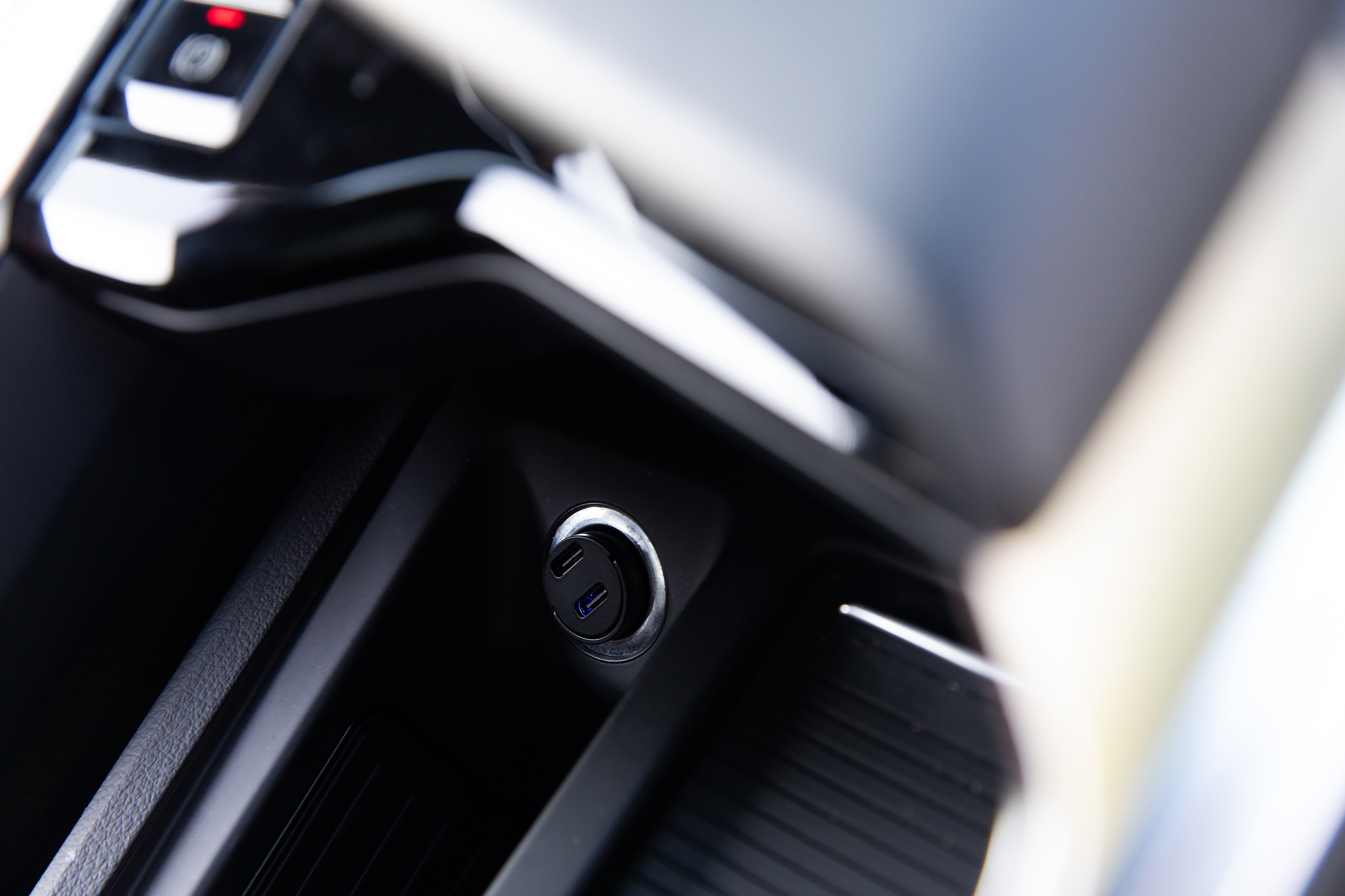 Close-up van het interieur van een auto, met een USB-poort en andere dashboardfuncties.
