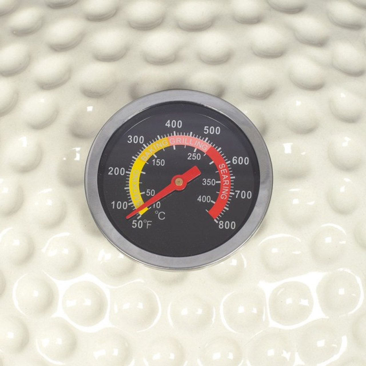 Nahaufnahme eines Grillthermometers. Das Zifferblatt zeigt Temperaturwerte, Bereiche für Grillen und Anbraten.