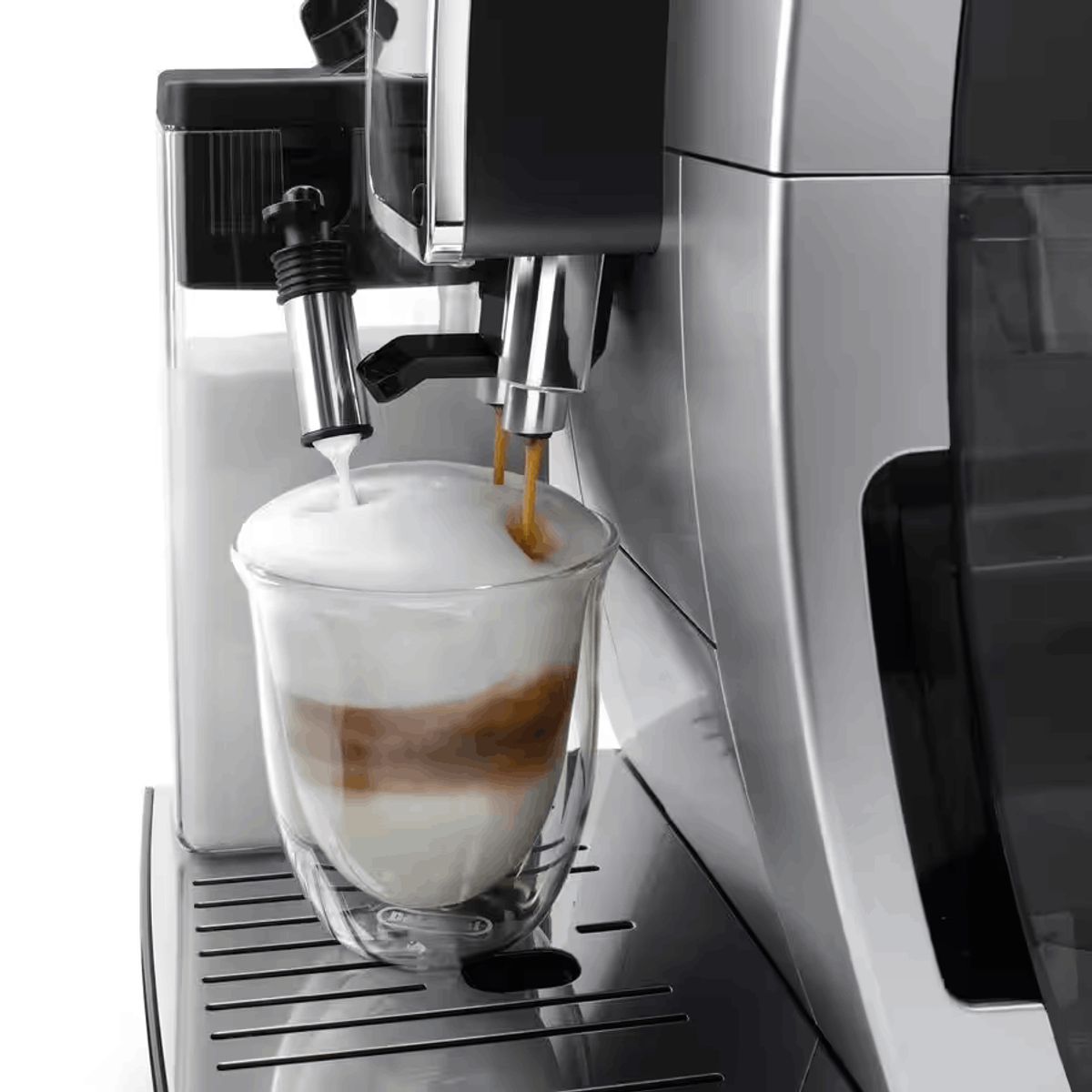 Máquina de café dispensando café y espuma de leche en un vaso, creando una bebida en capas.
