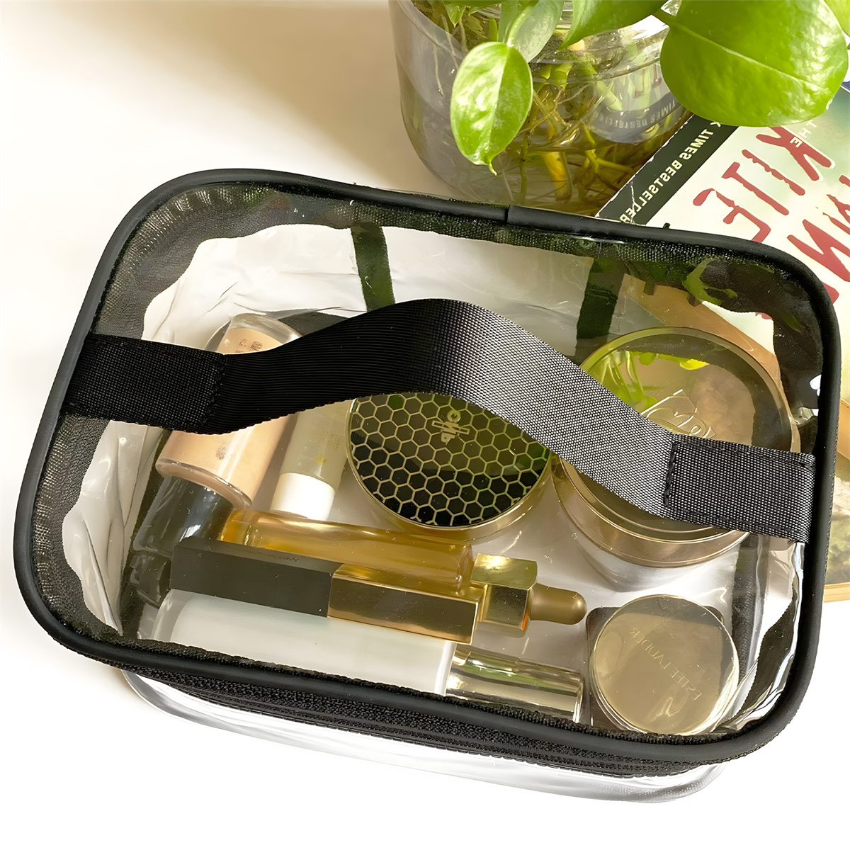Eine transparente Make-up-Tasche mit verschiedenen Kosmetikartikeln steht auf einer weißen Oberfläche.