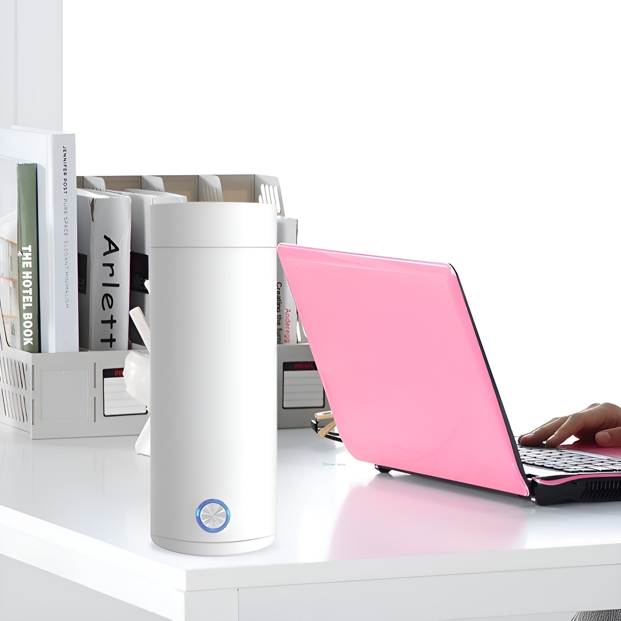 Eine weiße Thermosflasche mit einem rosa Laptop auf einem Schreibtisch.
