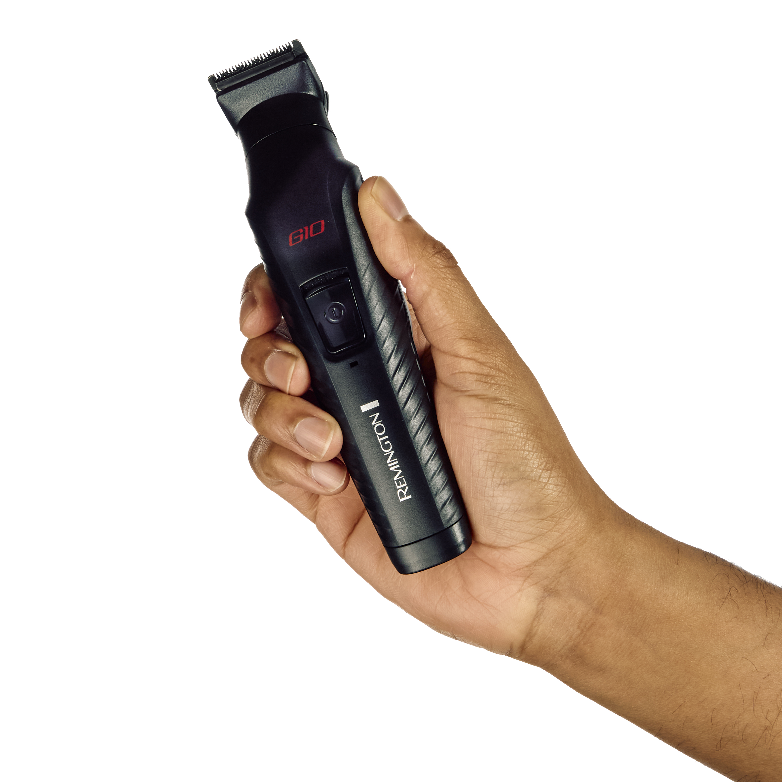 Une main tient une tondeuse Remington G60 noire. La tondeuse est noire avec du texte rouge.