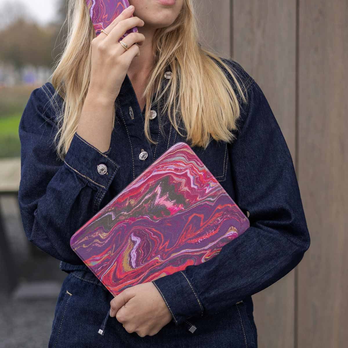 Een vrouw houdt een paarse gemarmerde tablethoes vast en belt.