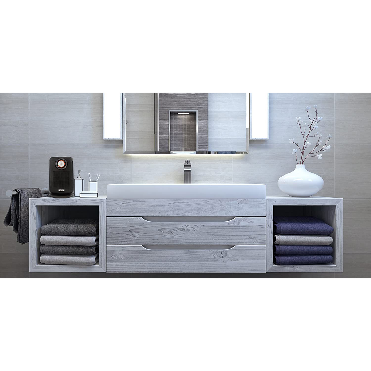 Mobile da bagno con specchio, asciugamani e un piccolo altoparlante nero.