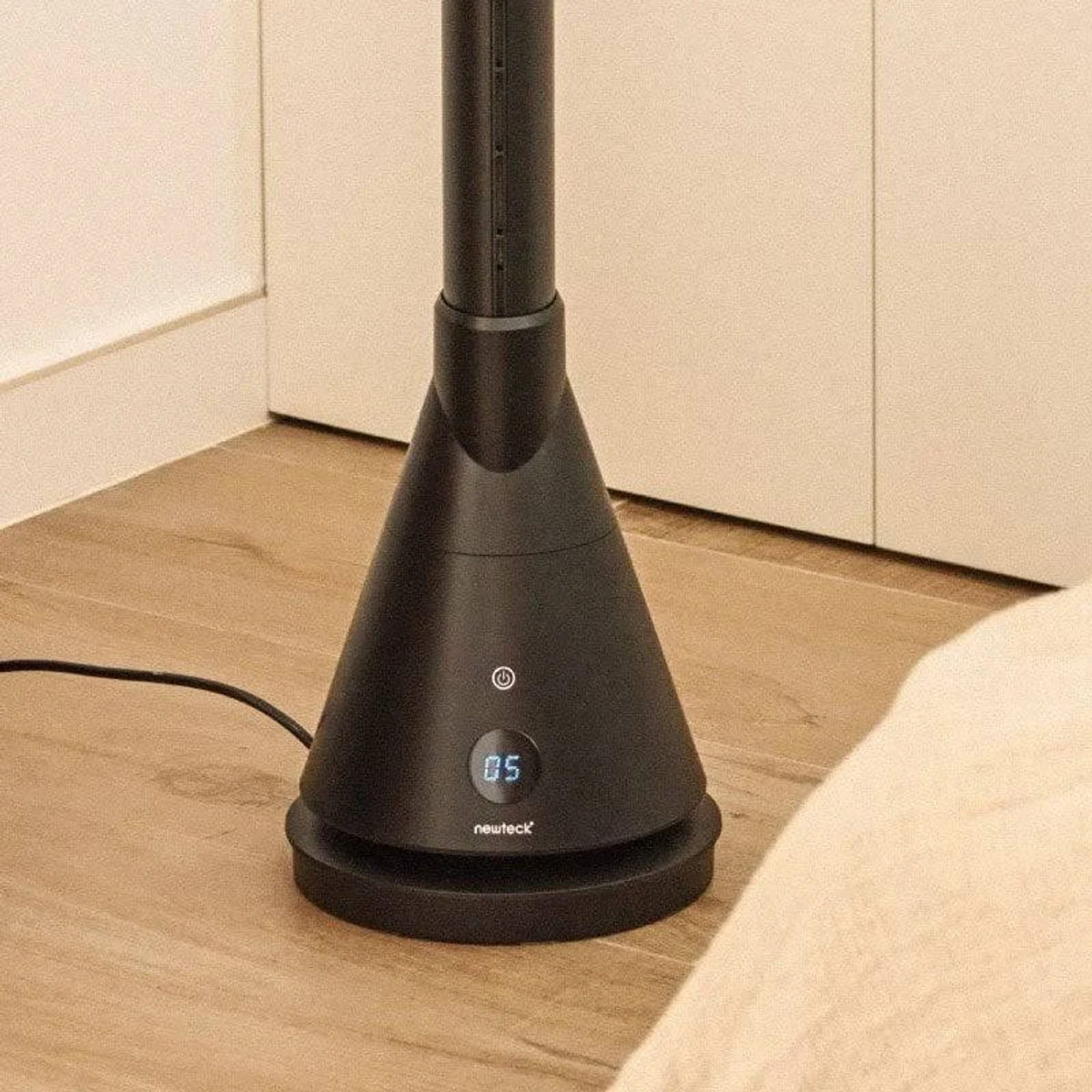 Un ventilador negro con pantalla digital y botón de encendido.