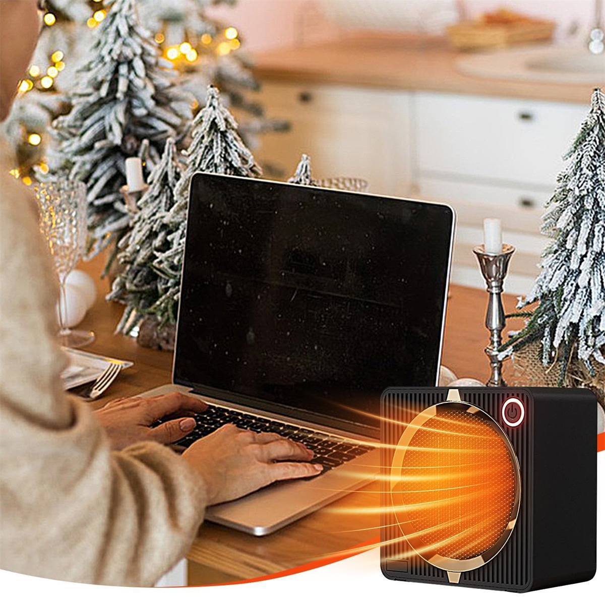 Eine Person benutzt einen Laptop in der Nähe eines kleinen Elektroheizers. Weihnachtsbäume sind im Hintergrund.