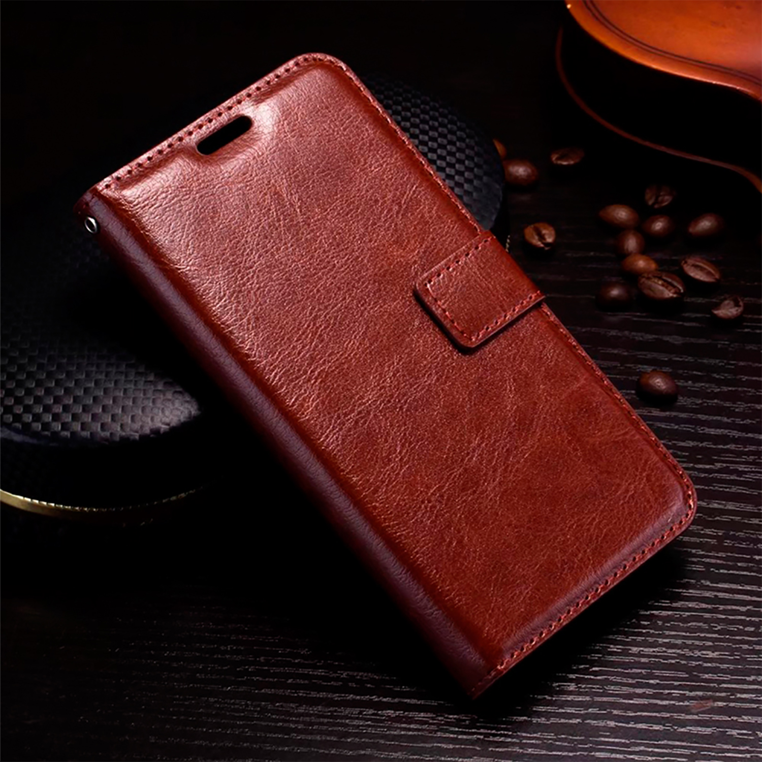Una custodia per telefono in pelle marrone chiusa con chiusura magnetica, su una superficie scura.