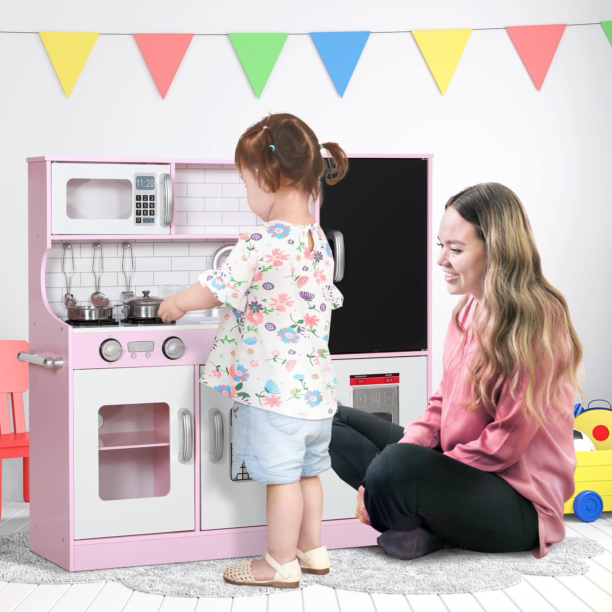 Un niño y un adulto jugando con una cocina de juguete.