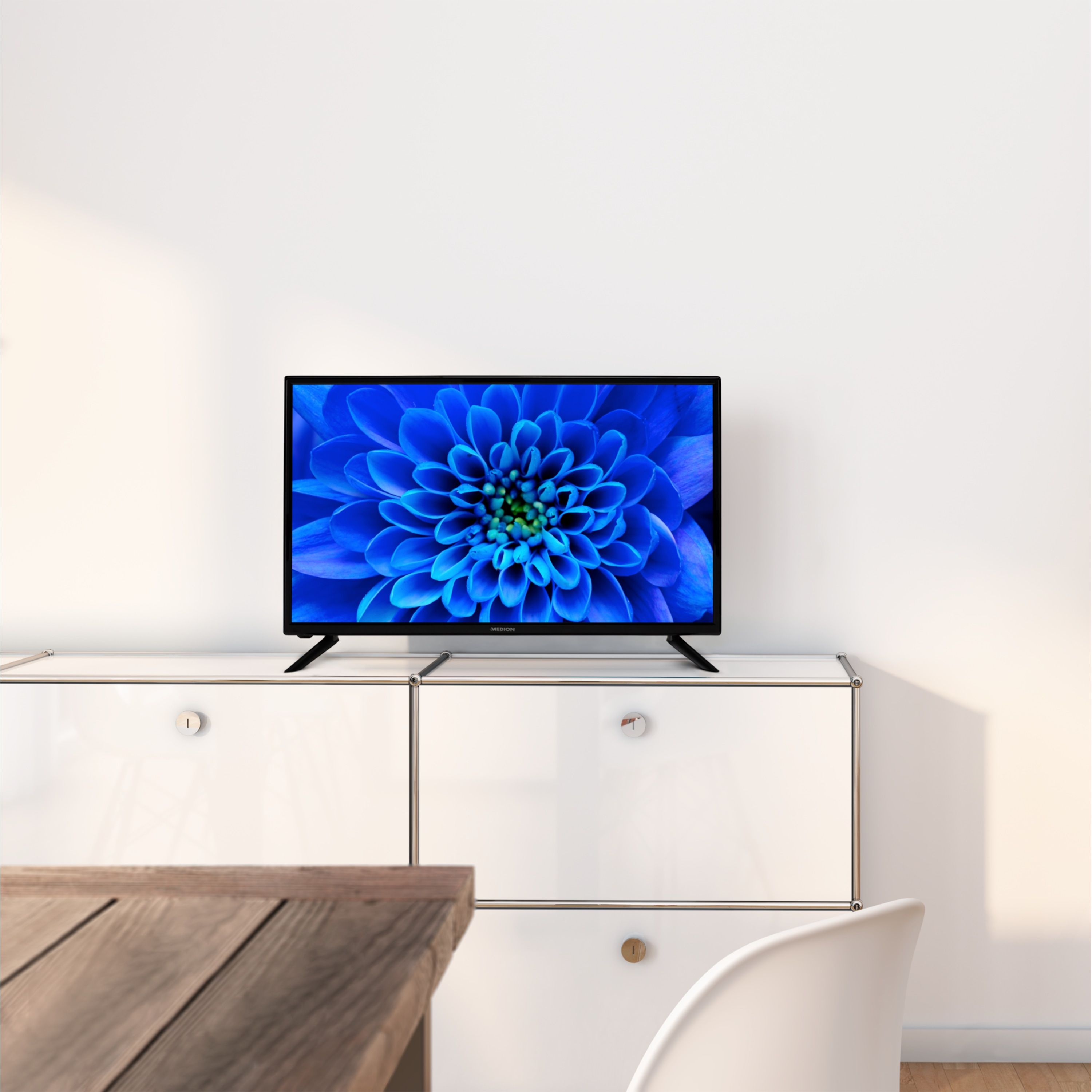 Tv op witte kast met bloemenafbeelding op scherm. Witte achtergrond.