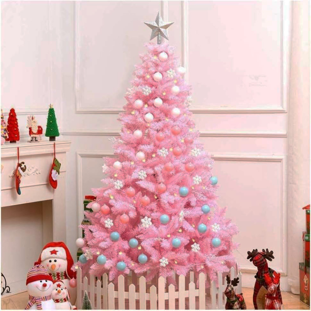 Árbol de Navidad rosa con adornos, una estrella, muñecos de nieve y una valla blanca.