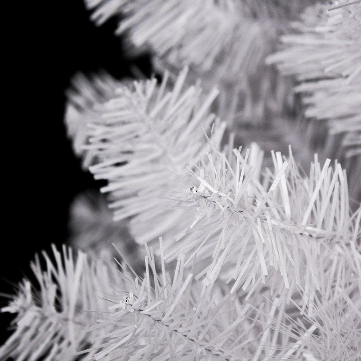 Primer plano de un árbol de Navidad artificial blanco con agujas blancas.