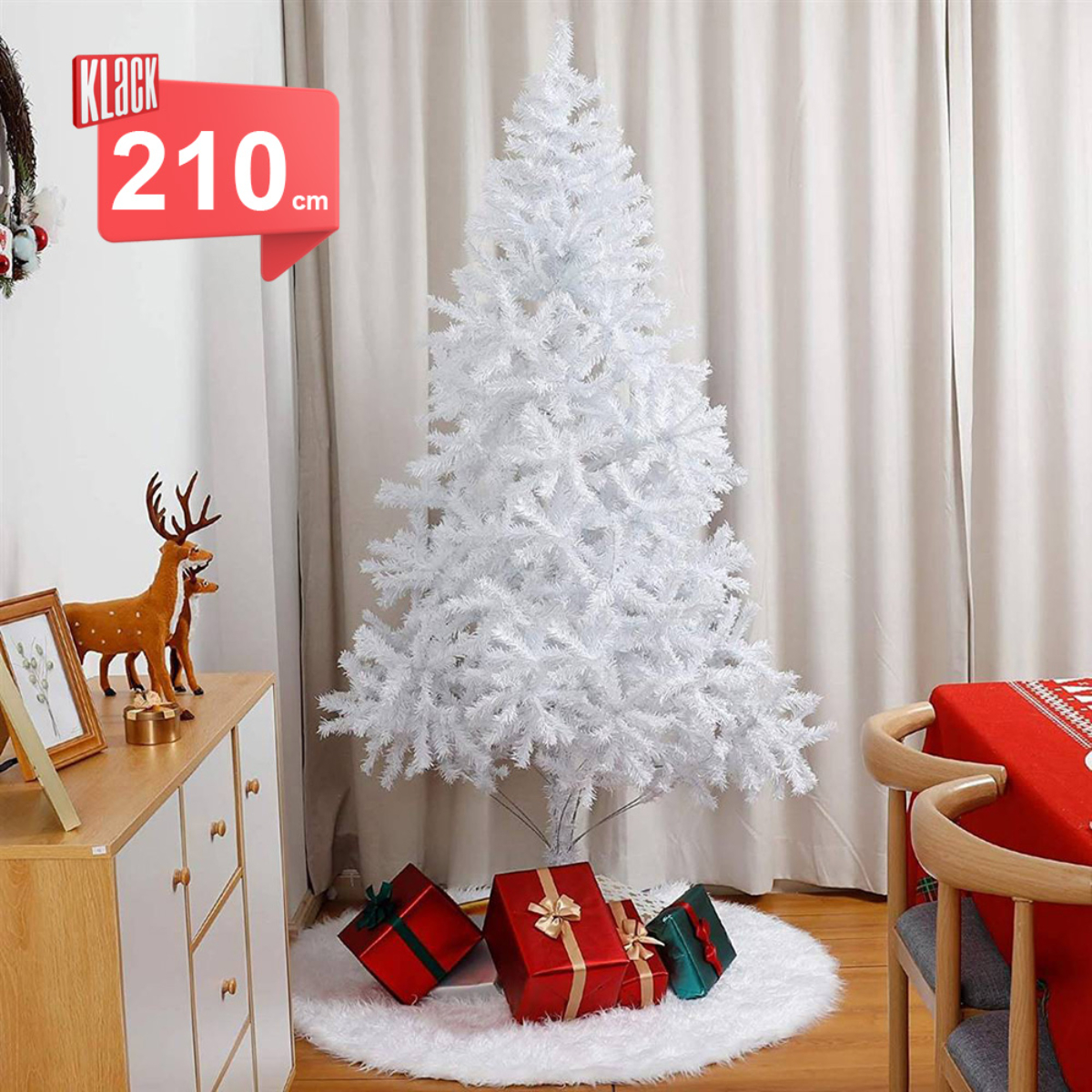 Árbol de Navidad blanco con regalos debajo y un mueble de madera. Etiqueta roja.