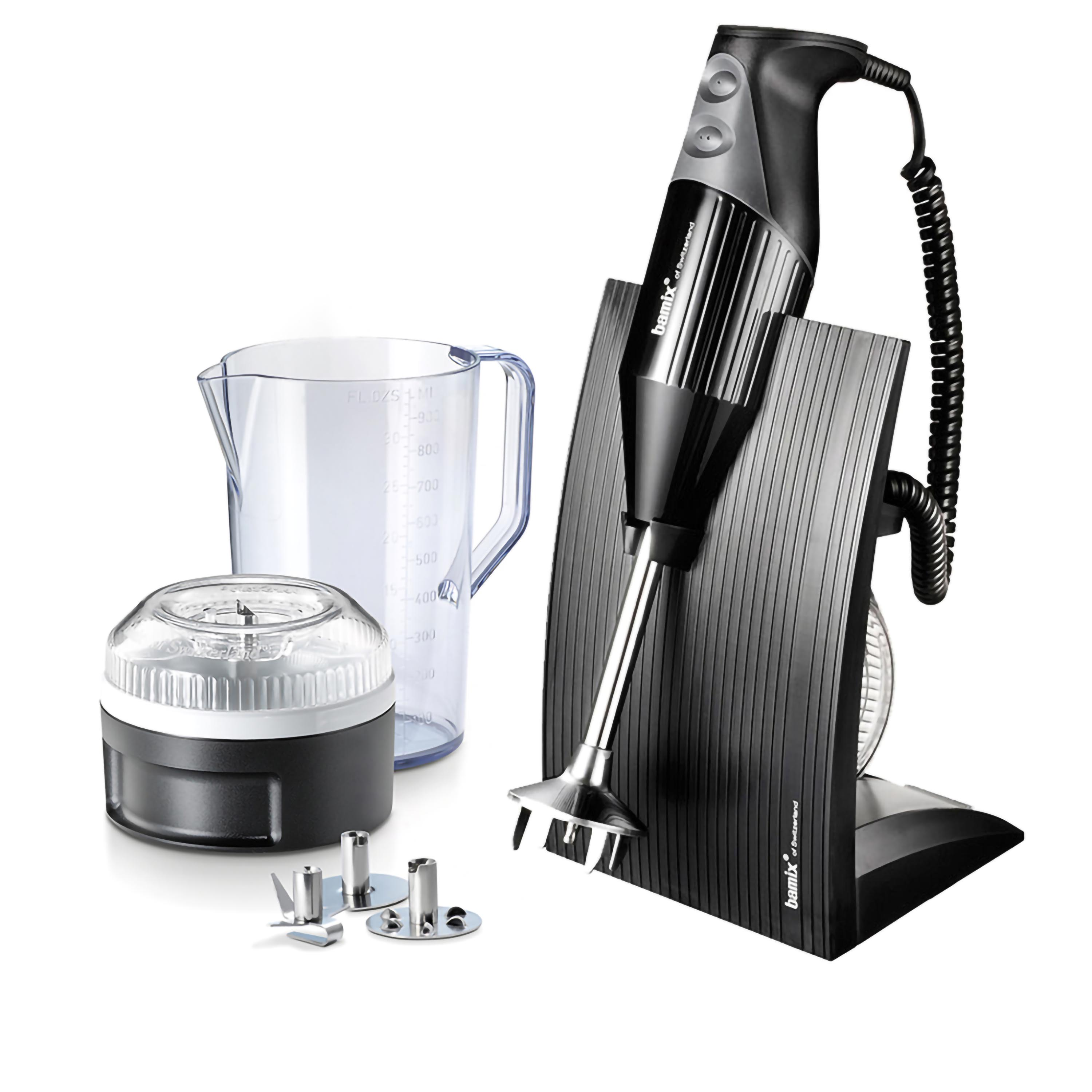 Un frullatore a immersione nero con accessori. Frullatore su un supporto nero, con una caraffa trasparente e altre parti.