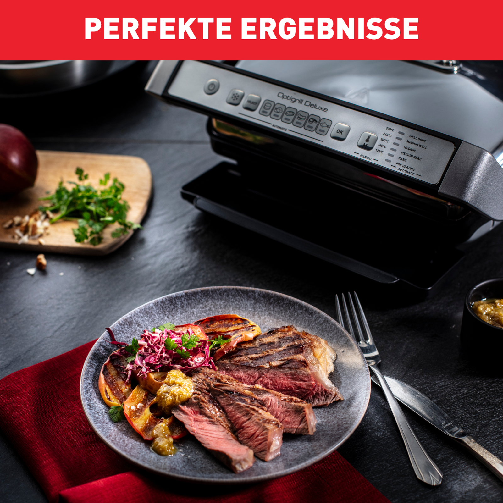 Gegrilltes Steak mit Gemüse und ein Grill auf schwarzer Oberfläche.