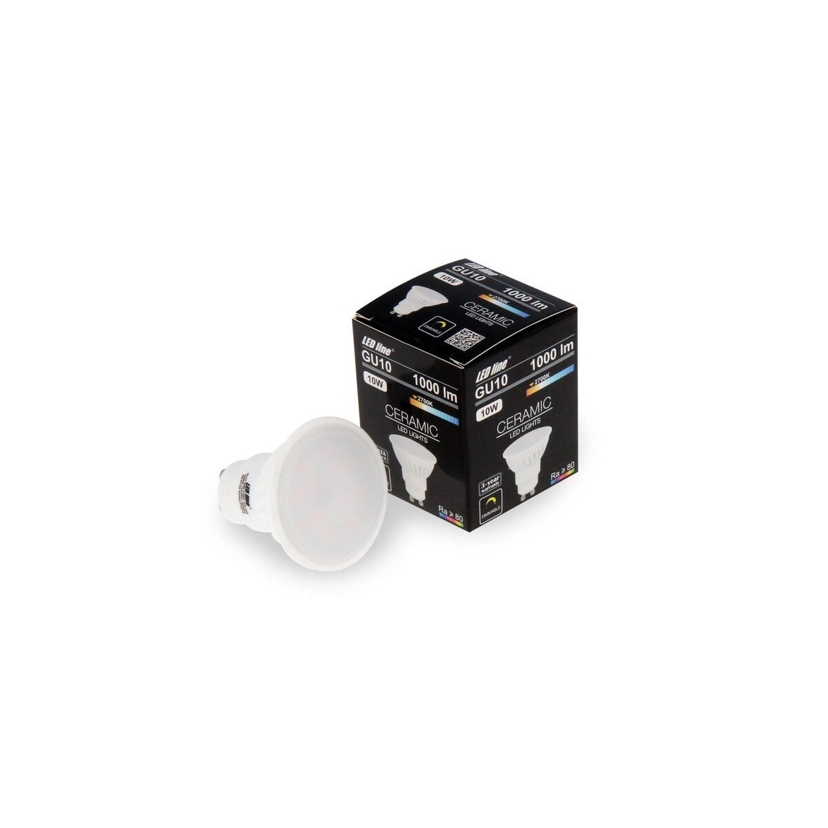 Eine weiße LED-Glühbirne und ihre Schachtel liegen auf einer weißen Oberfläche. Die Schachtel ist schwarz mit weißem Text, die Birne ist Keramik.