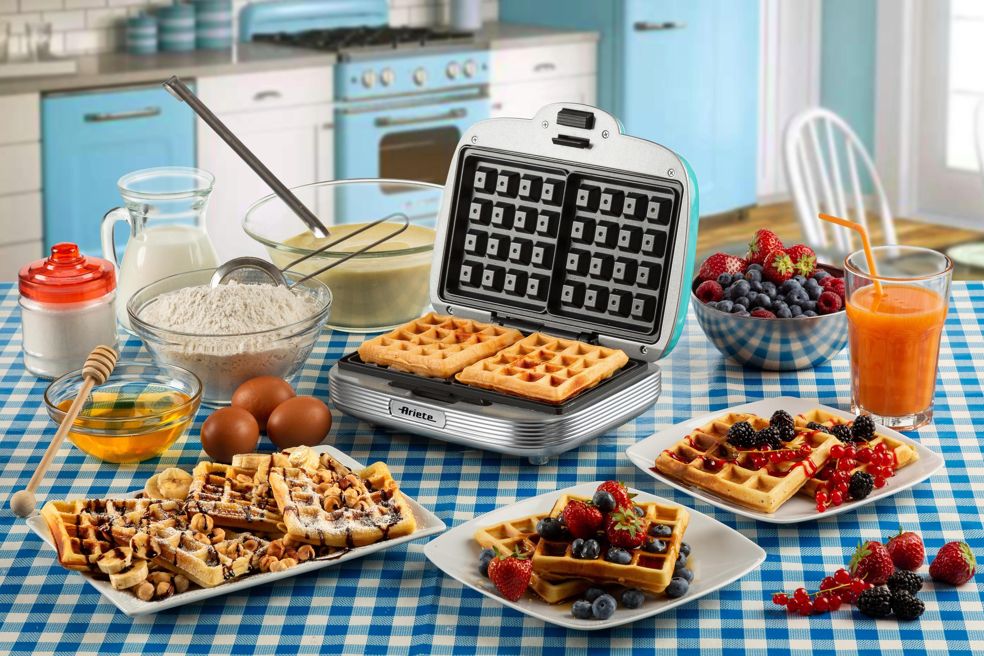 Een keuken met wafels, fruit en een wafelijzer.