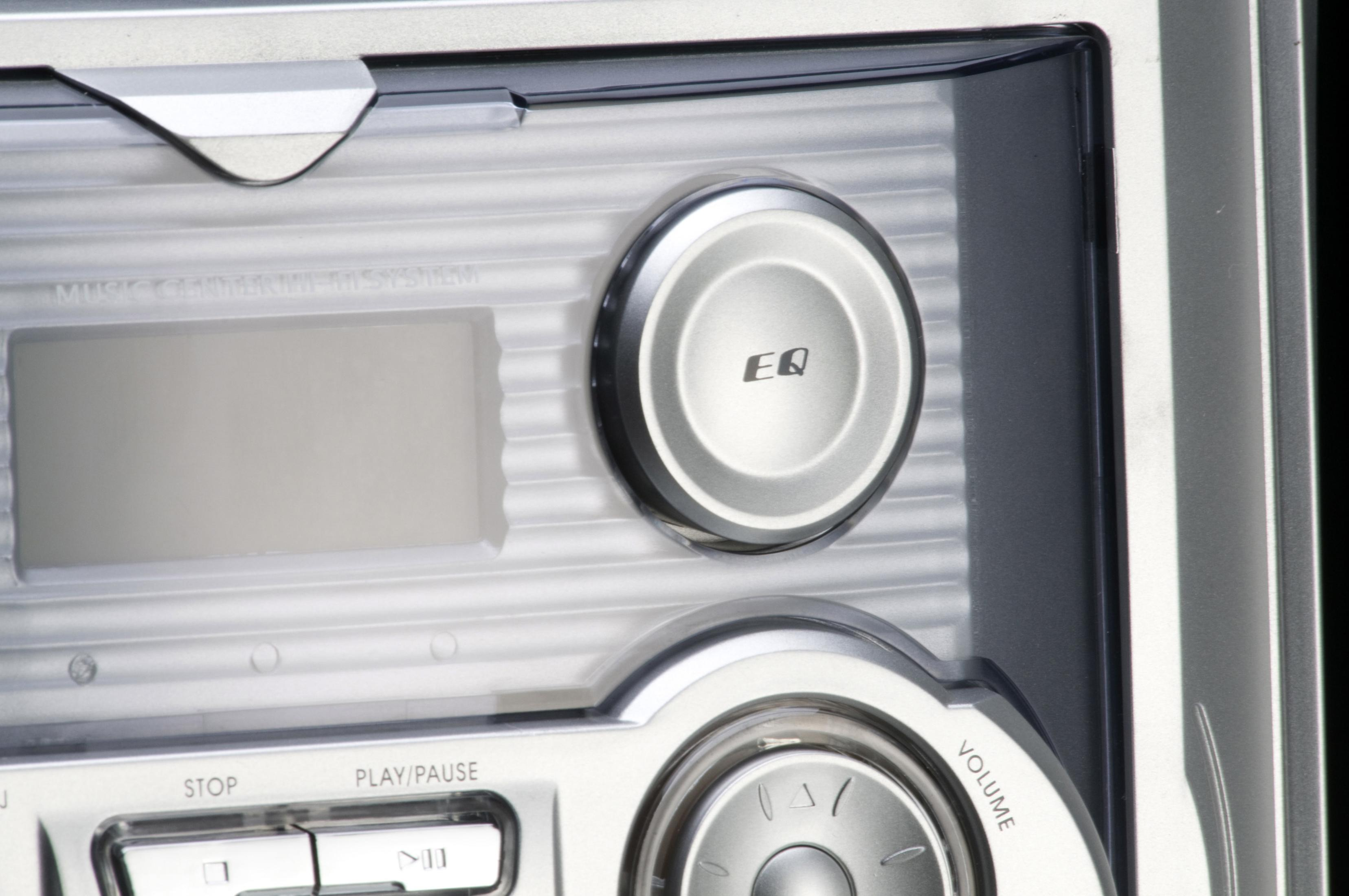 Nahaufnahme eines silbernen Radios mit EQ-Taste, Display und Lautstärke.