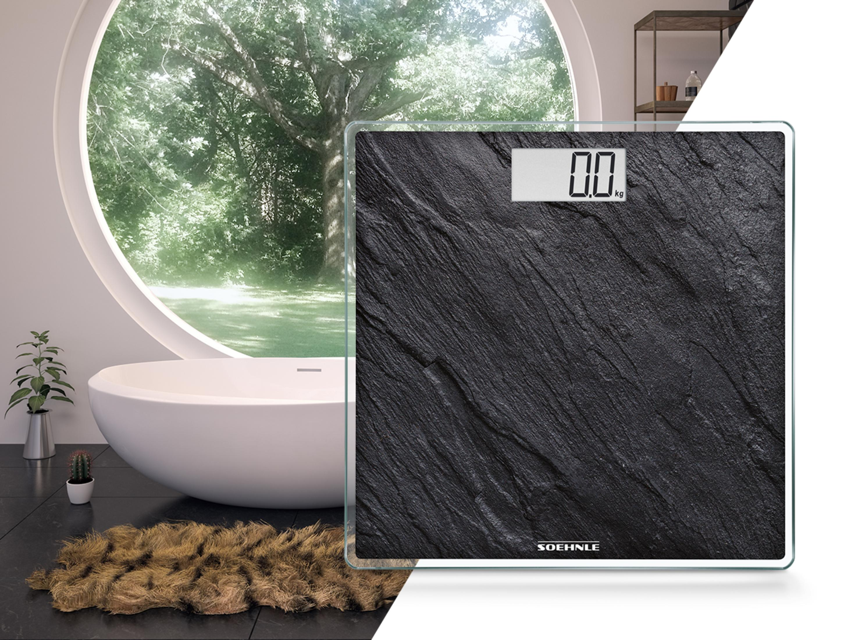 Scena łazienkowa z wagą cyfrową, wanną i oknem na drzewa.