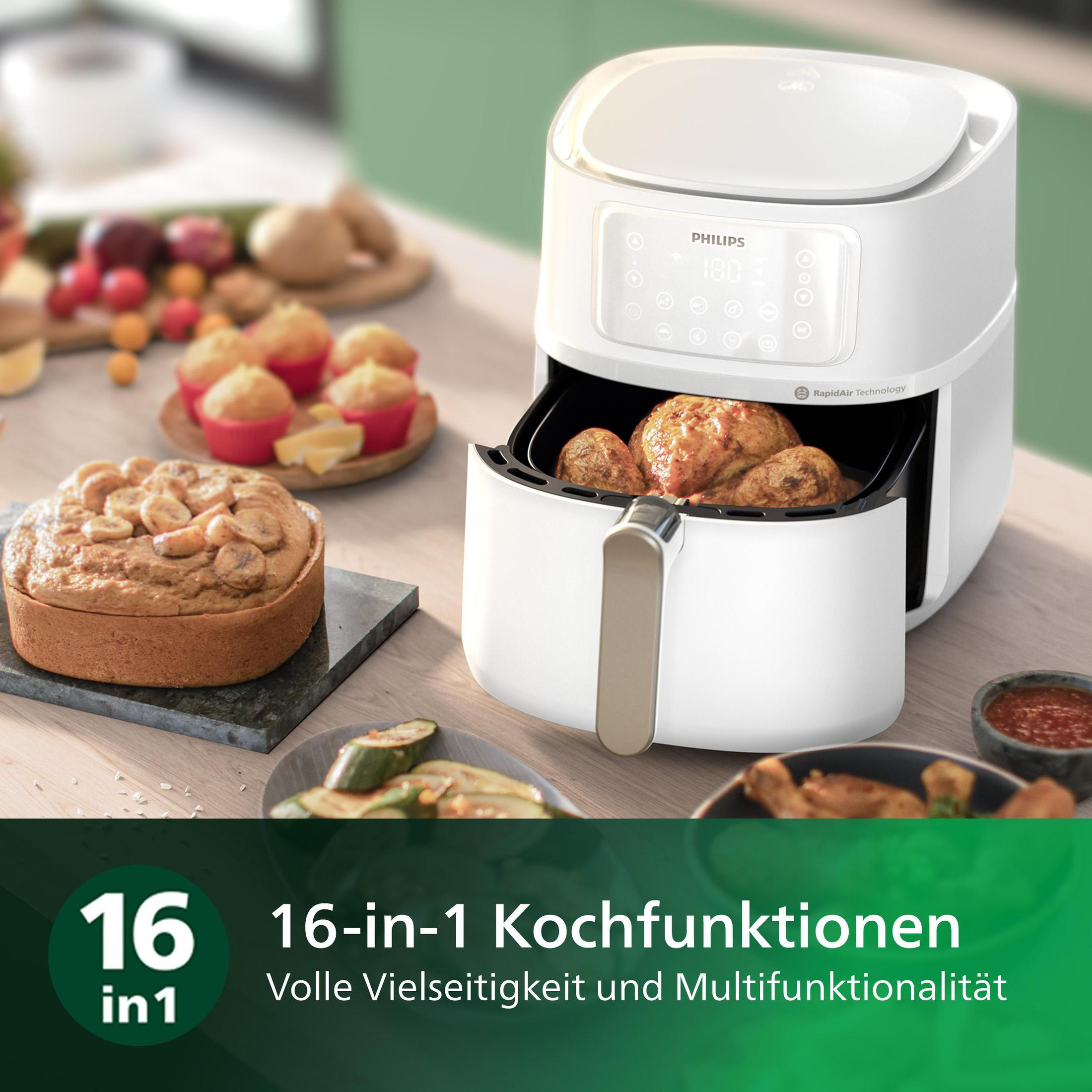 Airfryer Philips blanc avec de la nourriture à l'intérieur et sur la table. Texte : fonctions de cuisson 16 en 1.