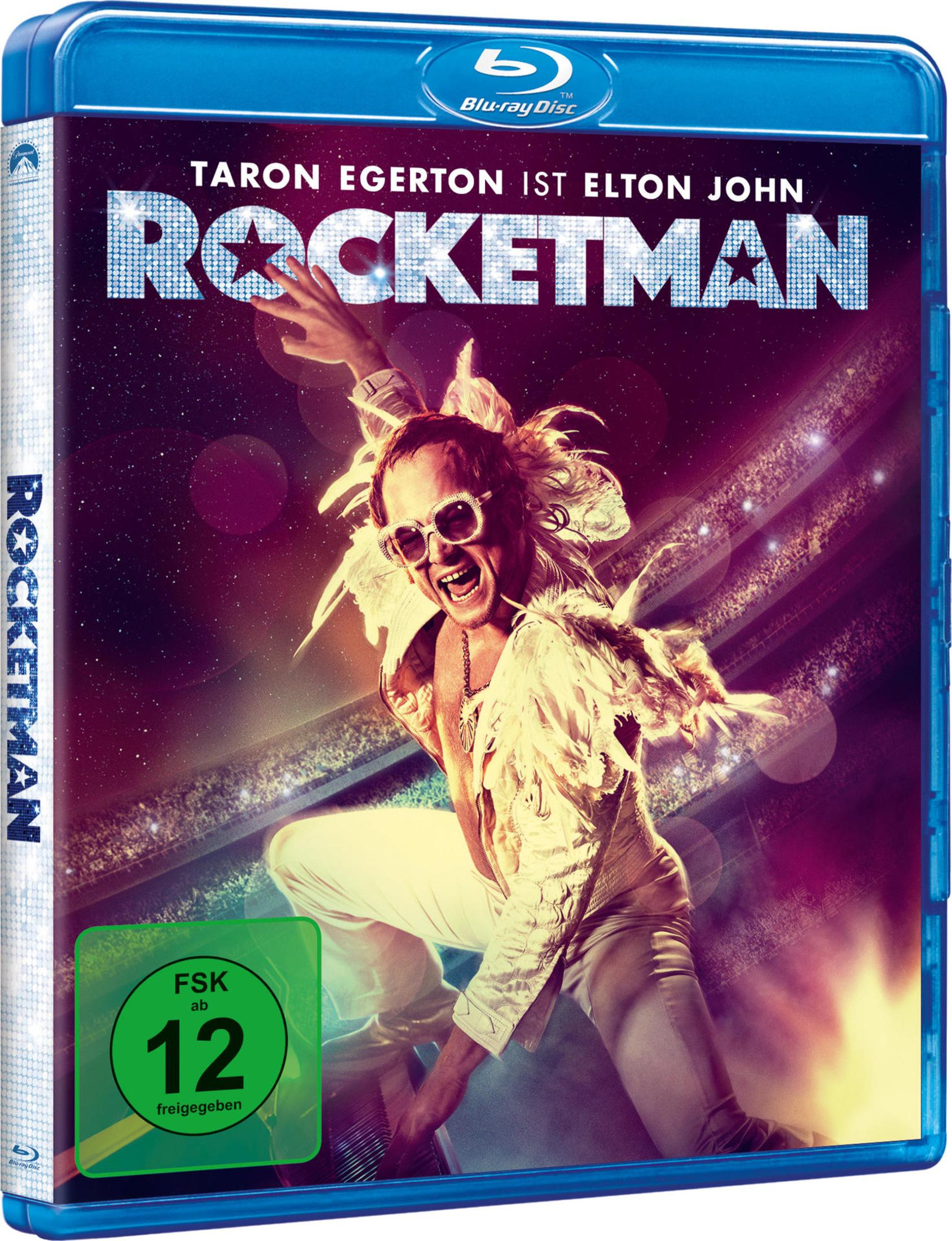 Rocketman Blu-ray-Hülle mit Taron Egerton in einem weißen Bühnenoutfit mit Federn und Sonnenbrille, der am Klavier auftritt.
