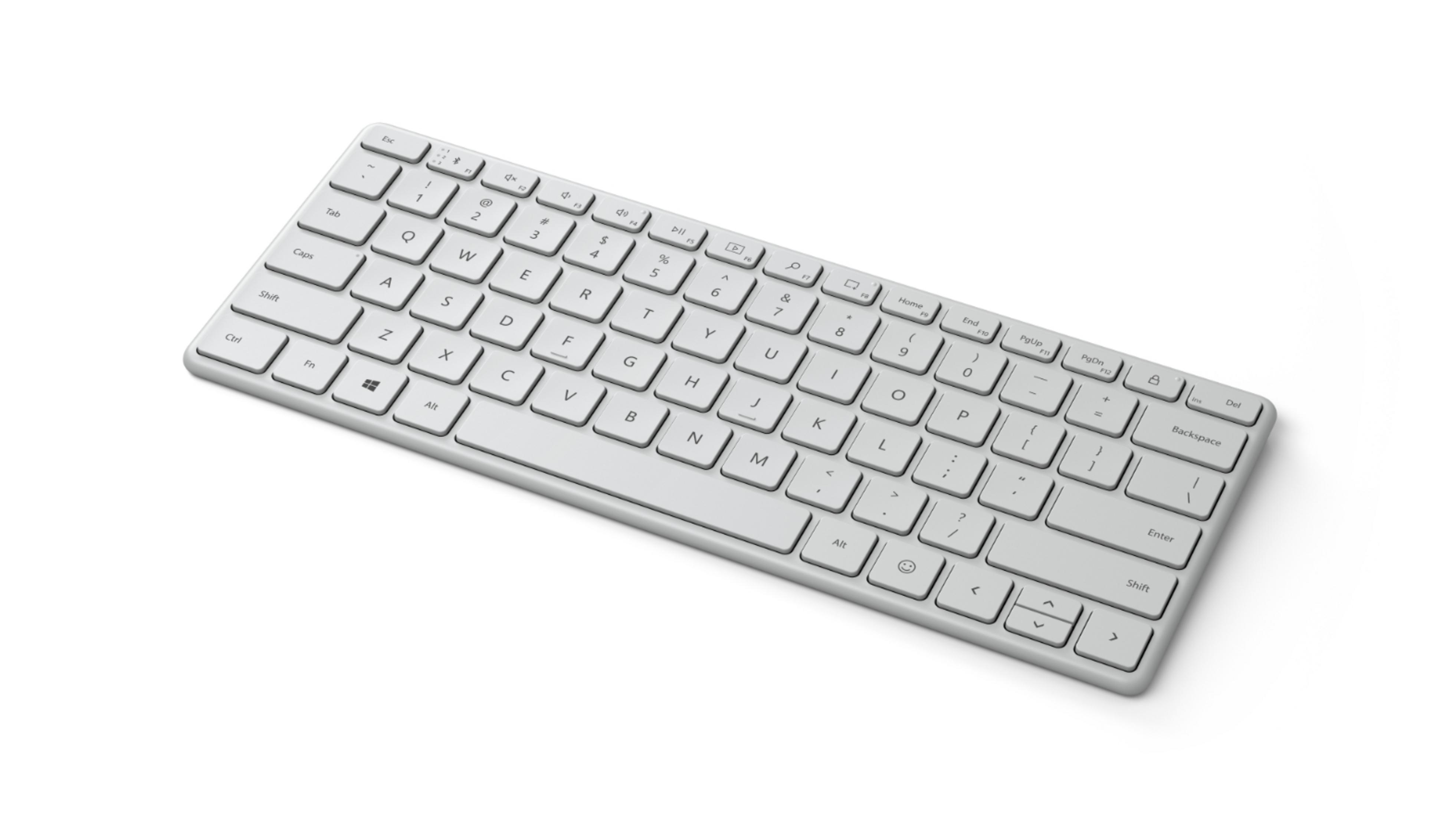 Un teclado blanco con teclas. Se ve desde un ángulo sobre un fondo blanco.