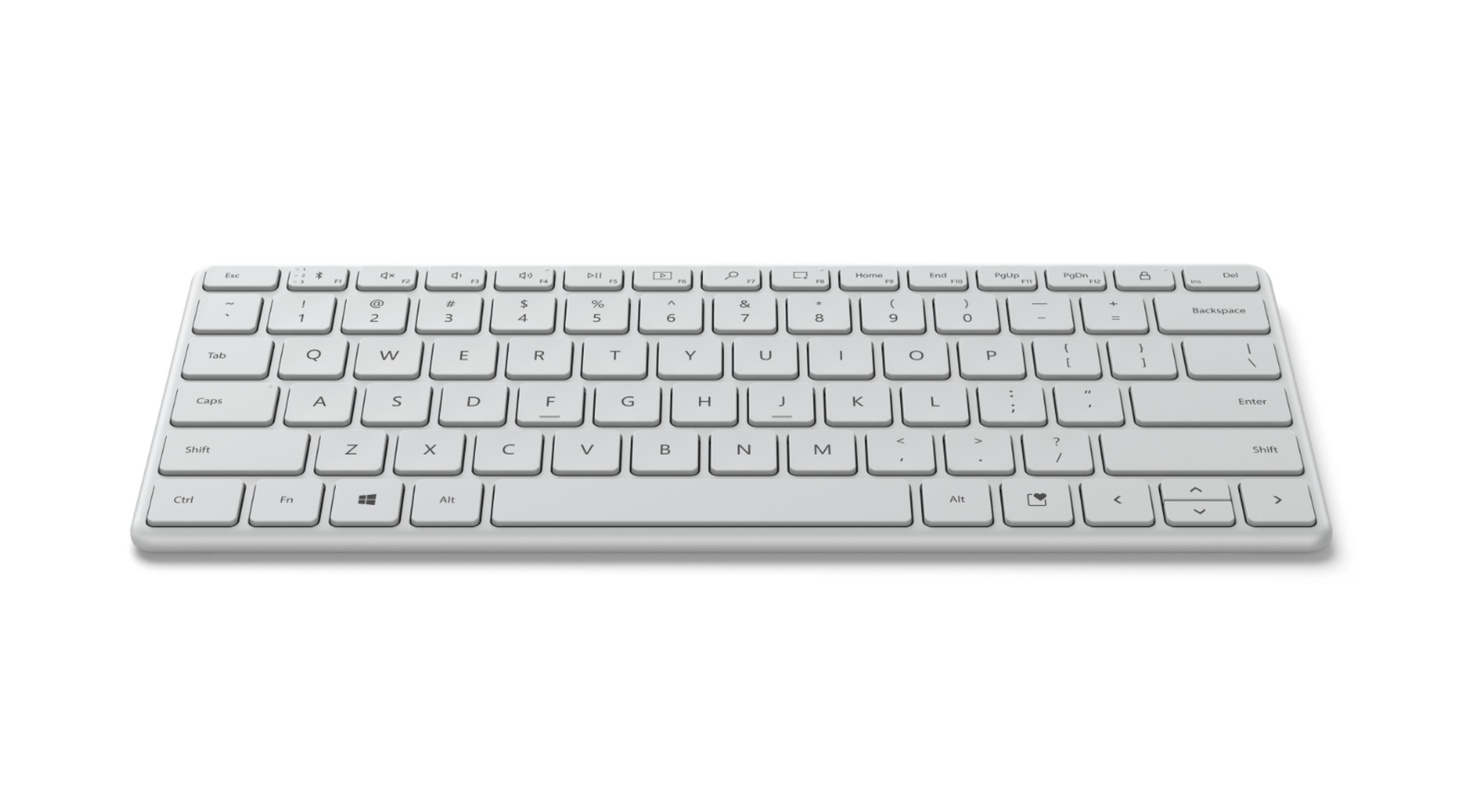 Un teclado de ordenador blanco, visto desde arriba sobre un fondo blanco. Tiene muchas teclas.