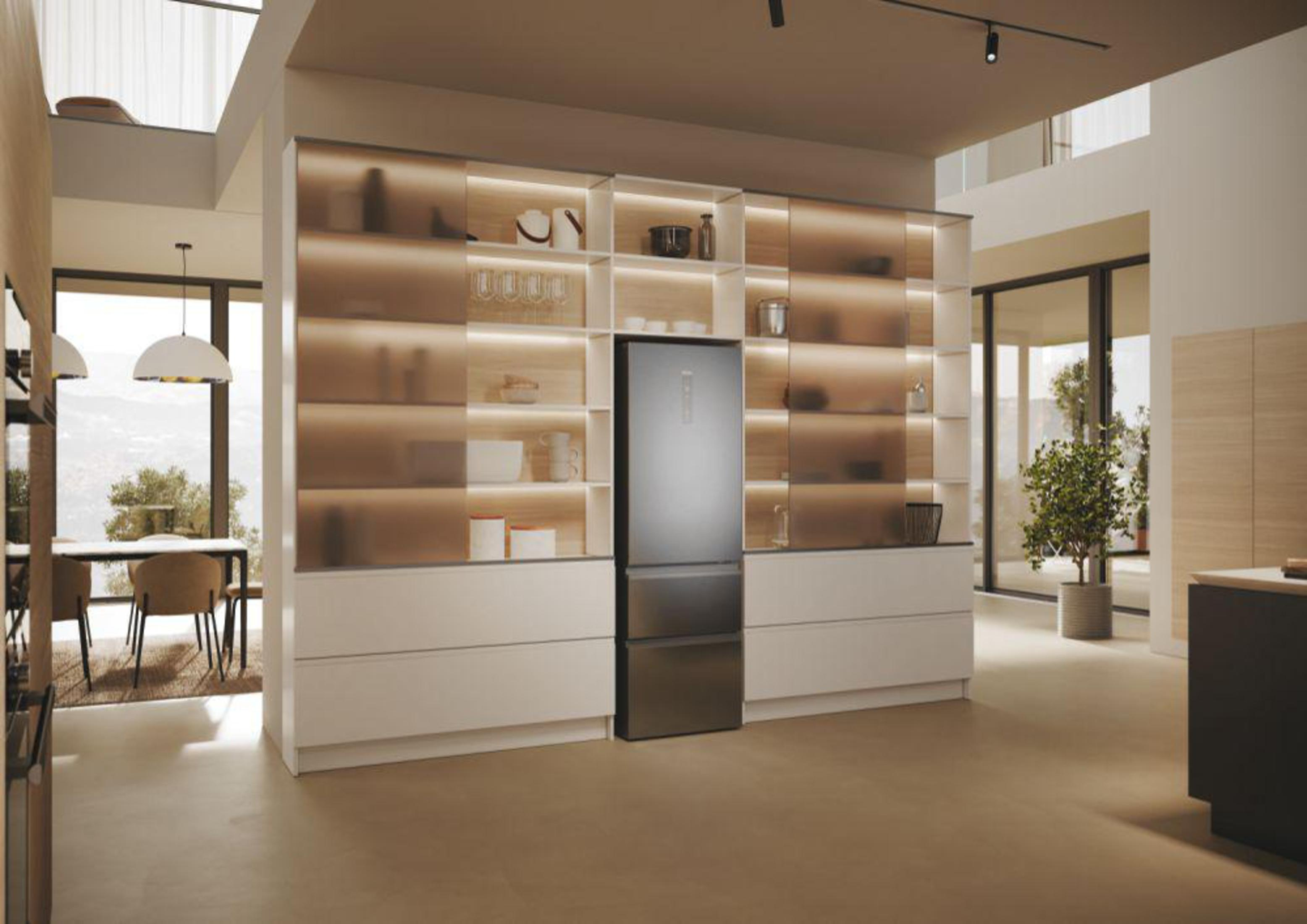 Interno cucina moderna con armadi a muro, un frigorifero e un piccolo albero. Pavimento beige.