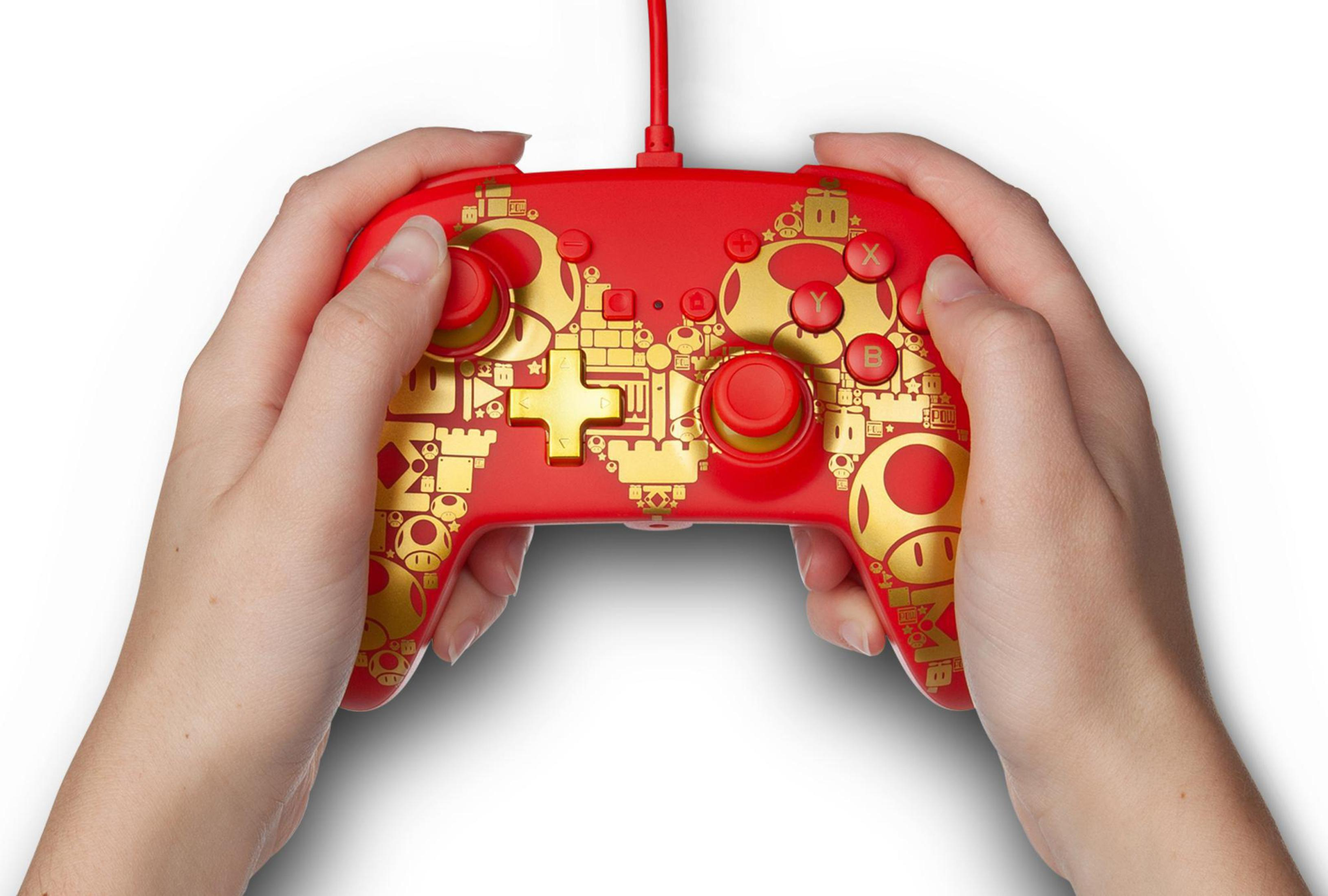Czerwony kontroler Nintendo Switch. Ozdobiony złotymi wzorami z motywem Mario.