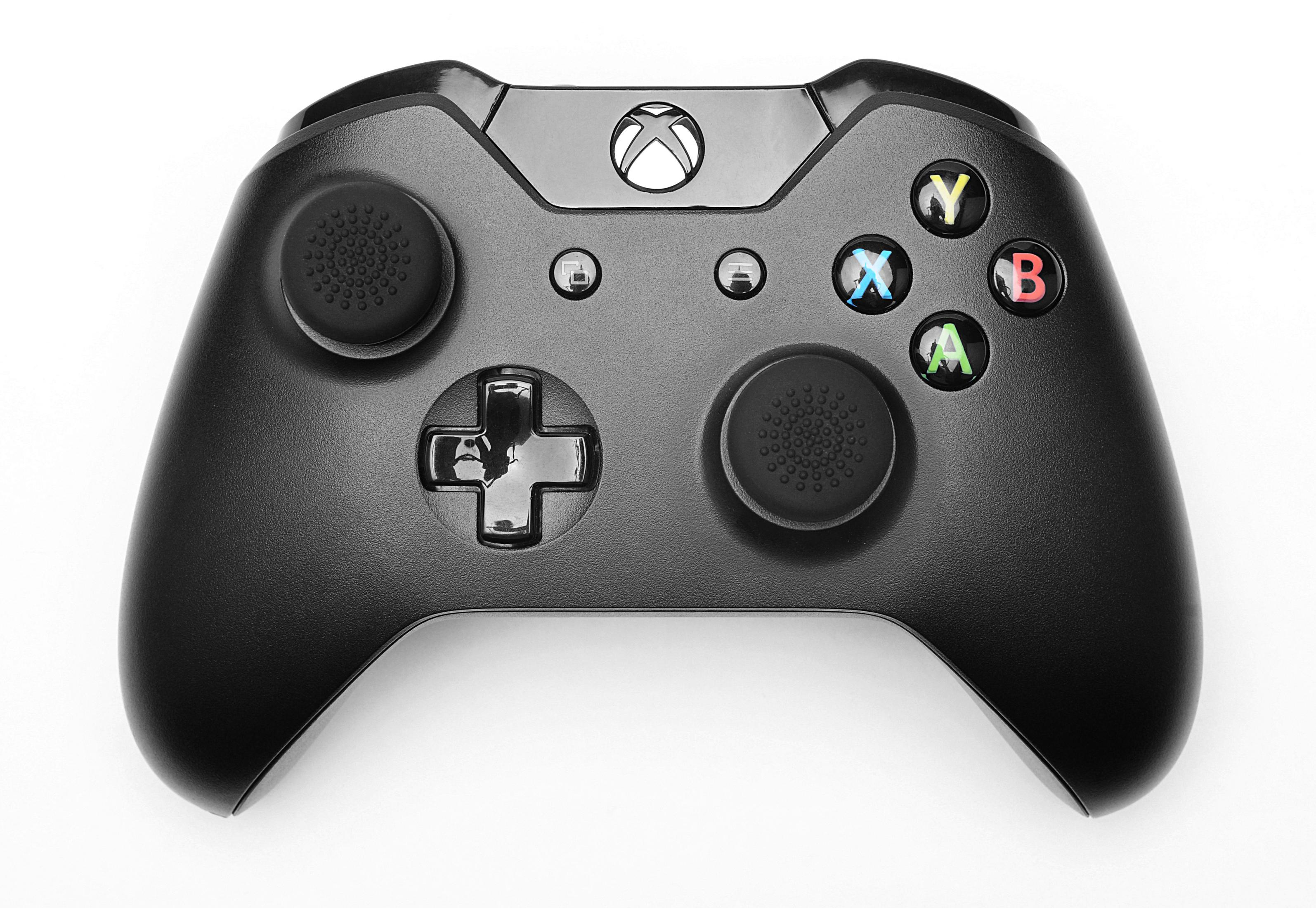 Schwarzer Xbox-Controller. Er hat Tasten mit Buchstaben und ein Steuerkreuz. Weißer Hintergrund.