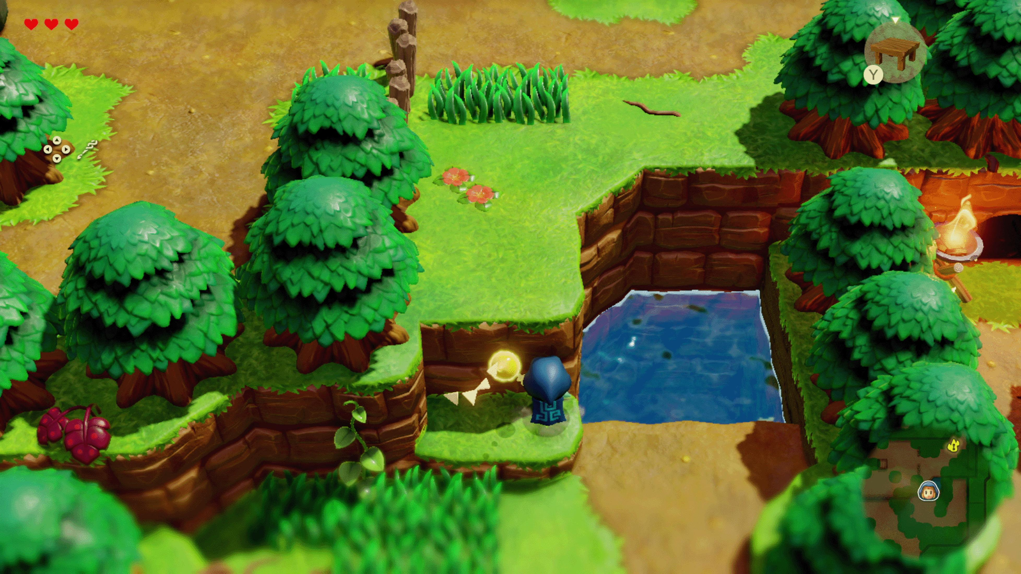 Widok z góry na kolorową scenę z gry wideo z drzewami, wodą i małą postacią.