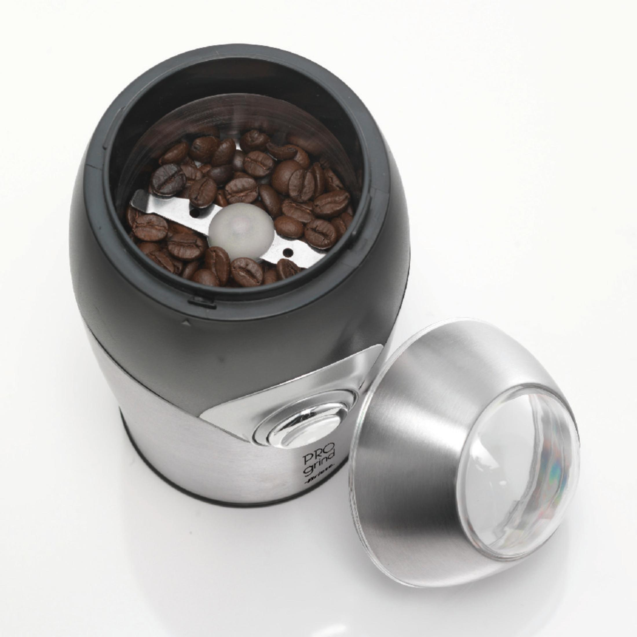 Eine Kaffeemühle mit Kaffeebohnen im Inneren und dem abgenommenen Deckel auf weißem Untergrund.