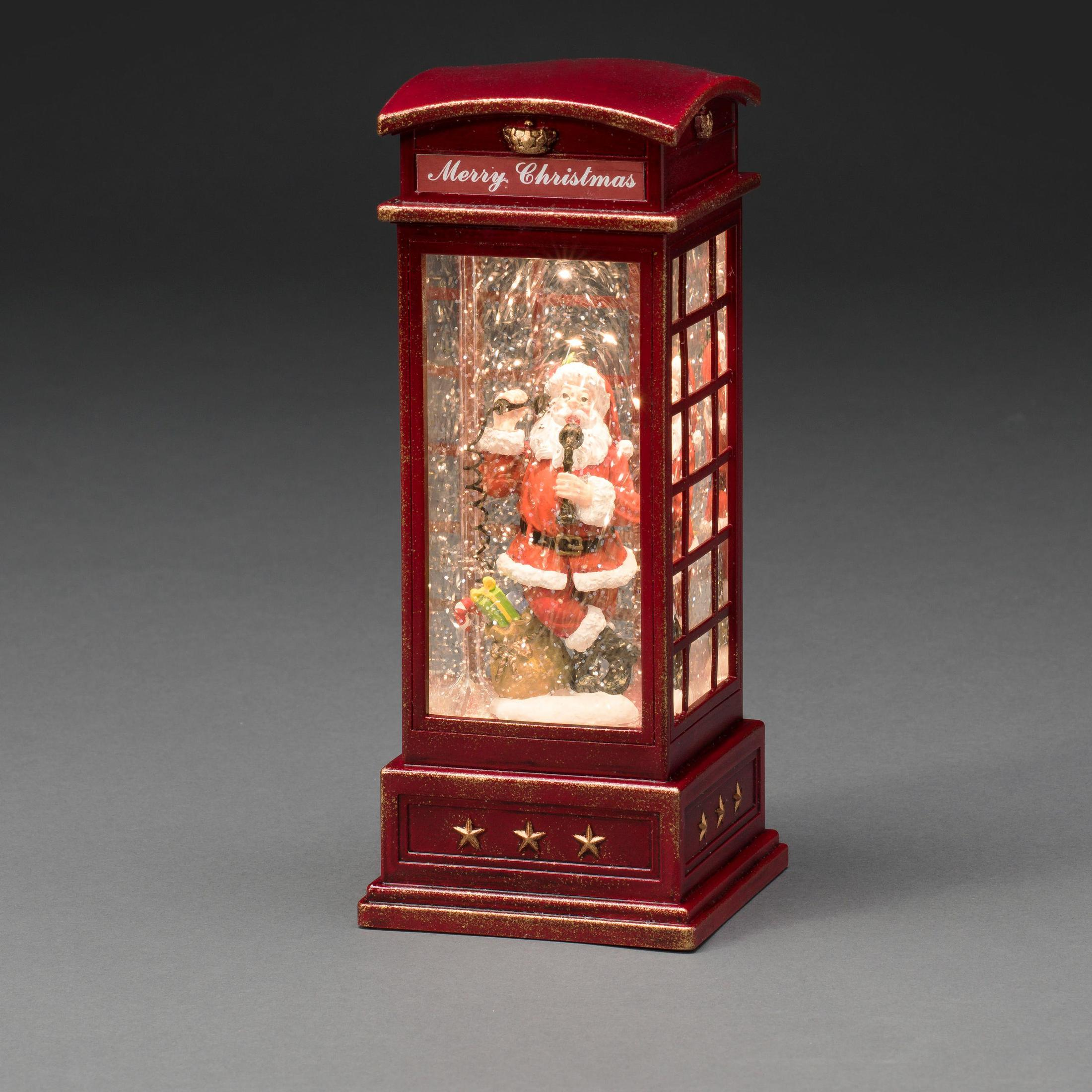 Eine rote Telefonzelle-Schneekugel mit Weihnachtsmann, der einen Vogel hält. Der Satz 'Merry Christmas' ist sichtbar.