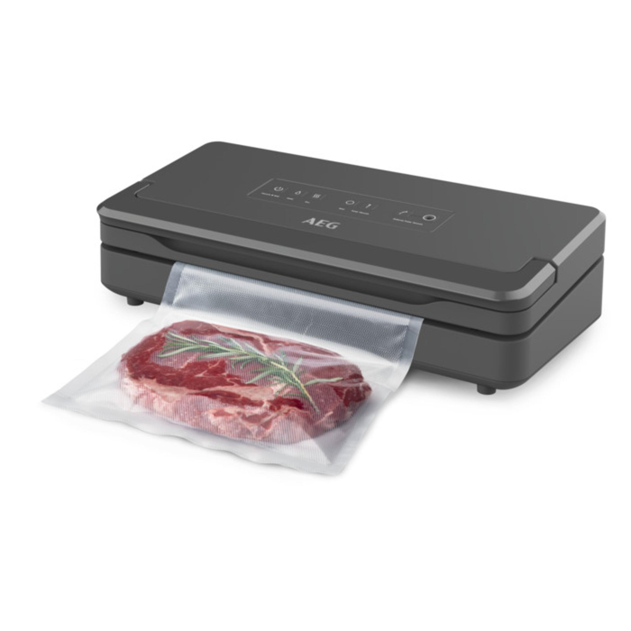 Eine Vakuumversiegelungsmaschine versiegelt ein Steak in einem transparenten Plastikbeutel.