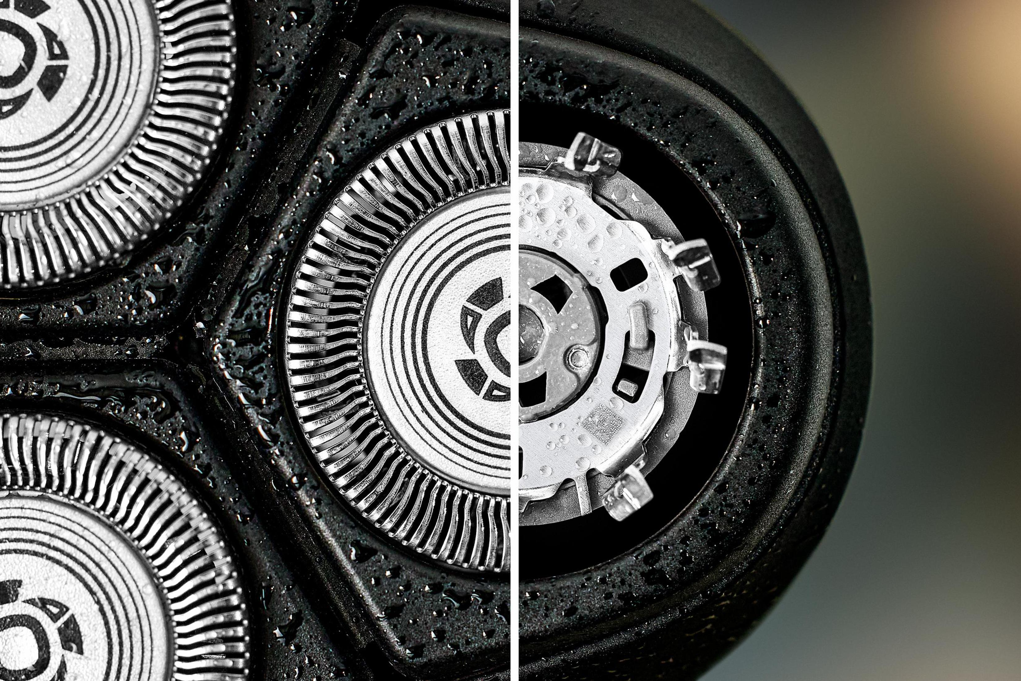 Zbliżenie głowicy golarki. Ostrza po lewej i elementy wewnętrzne po prawej, z kroplami wody.