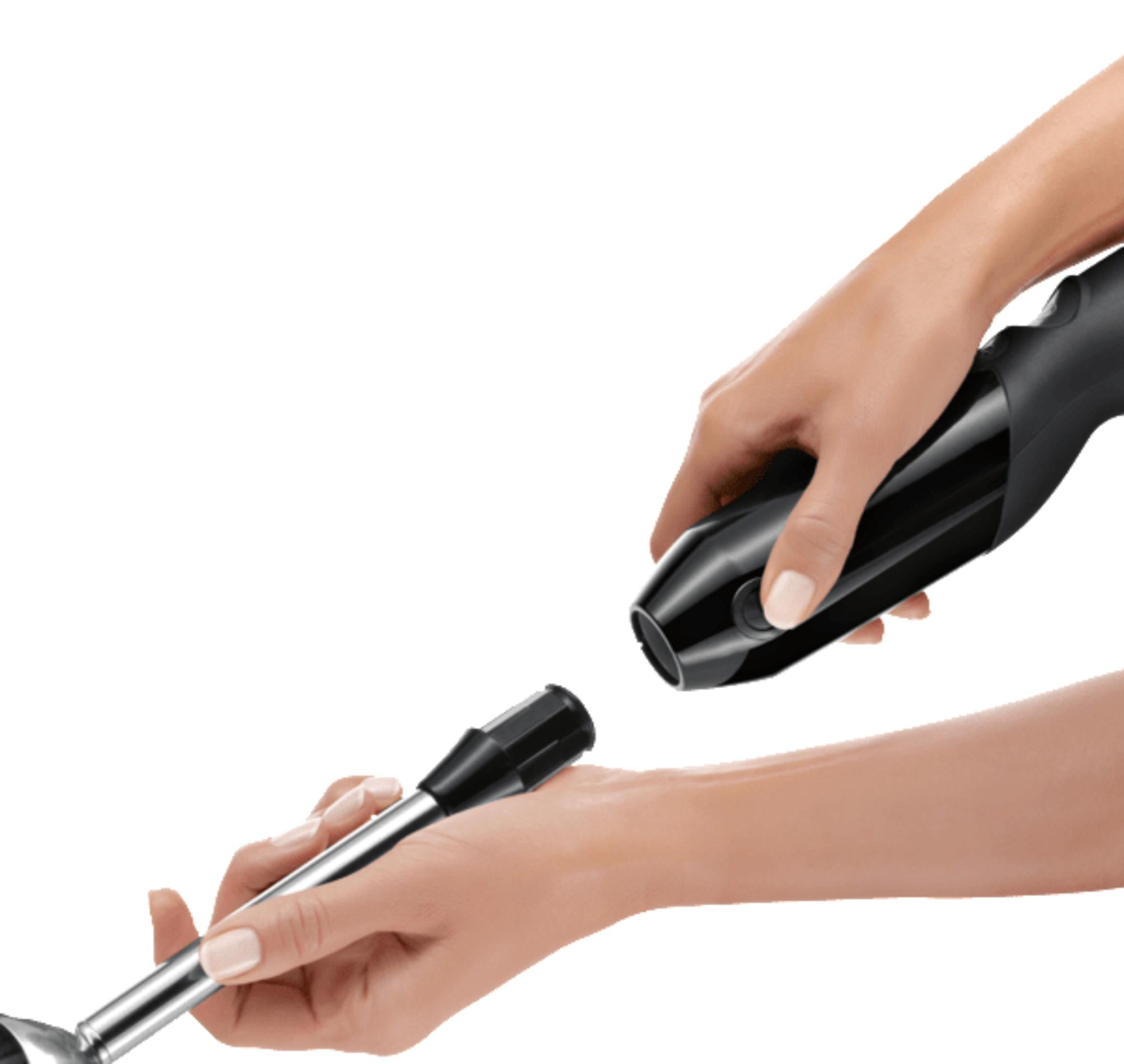 Osoba montująca czarny blender ręczny. Jedna ręka trzyma silnik, druga wkłada przystawkę do blendowania.