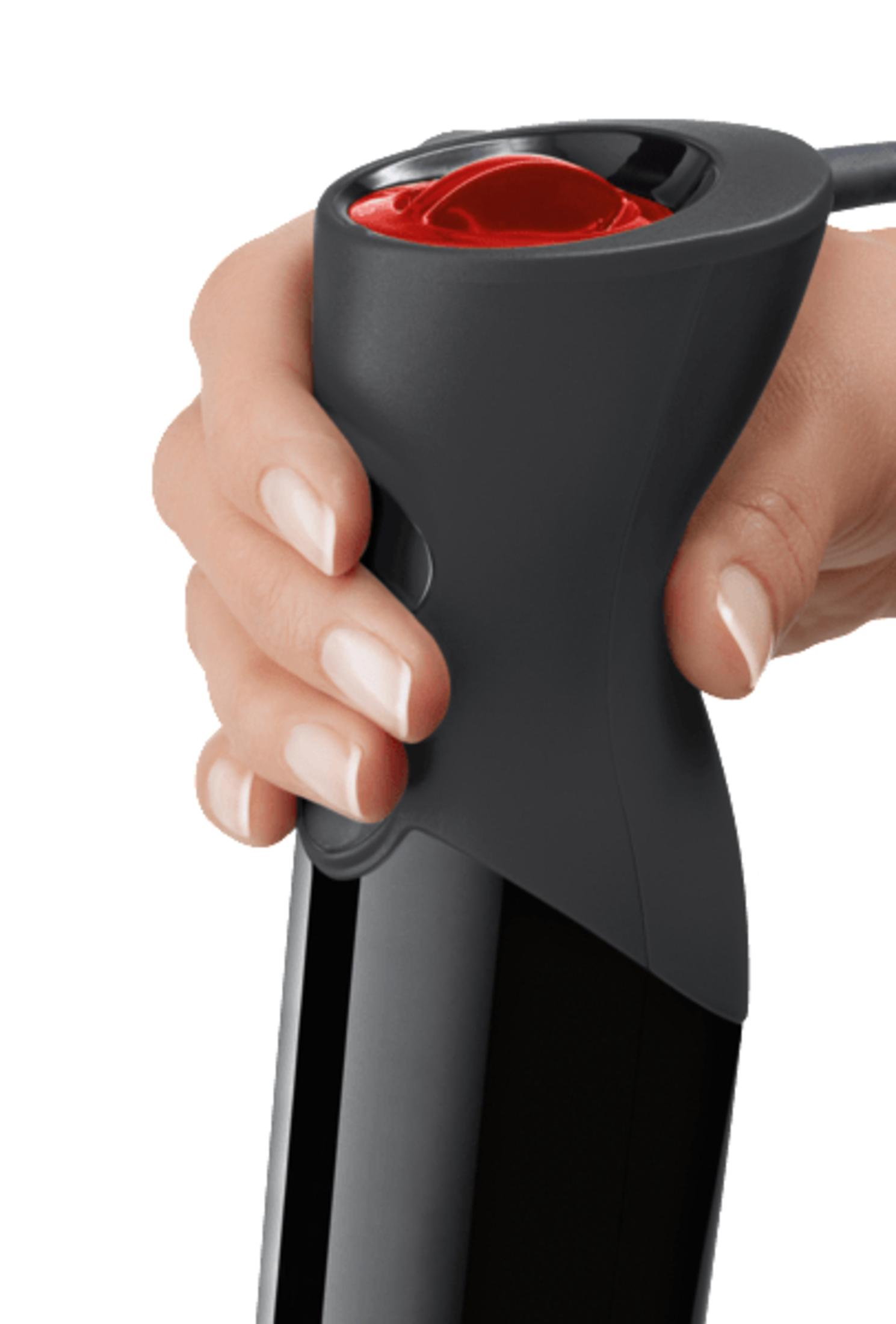 Dłoń trzymająca czarny blender ręczny, czerwony sos widoczny na górze.