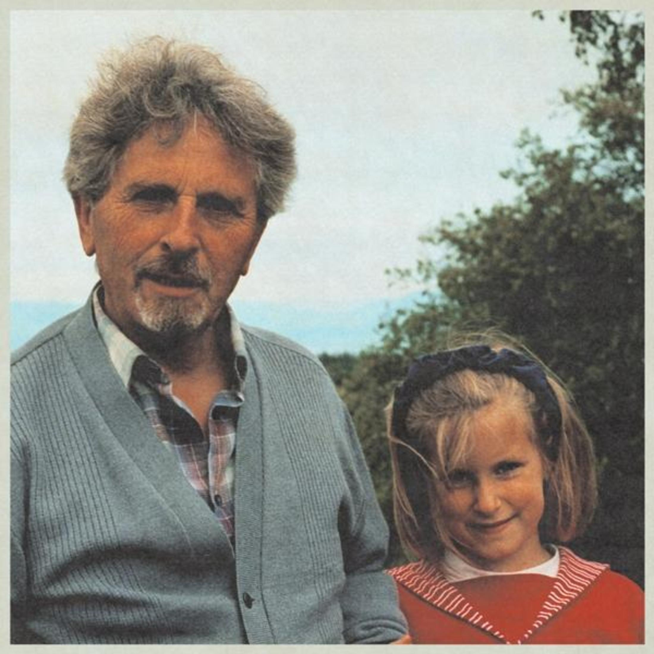 Foto: Un uomo e una bambina all'aperto, l'uomo indossa un cardigan.