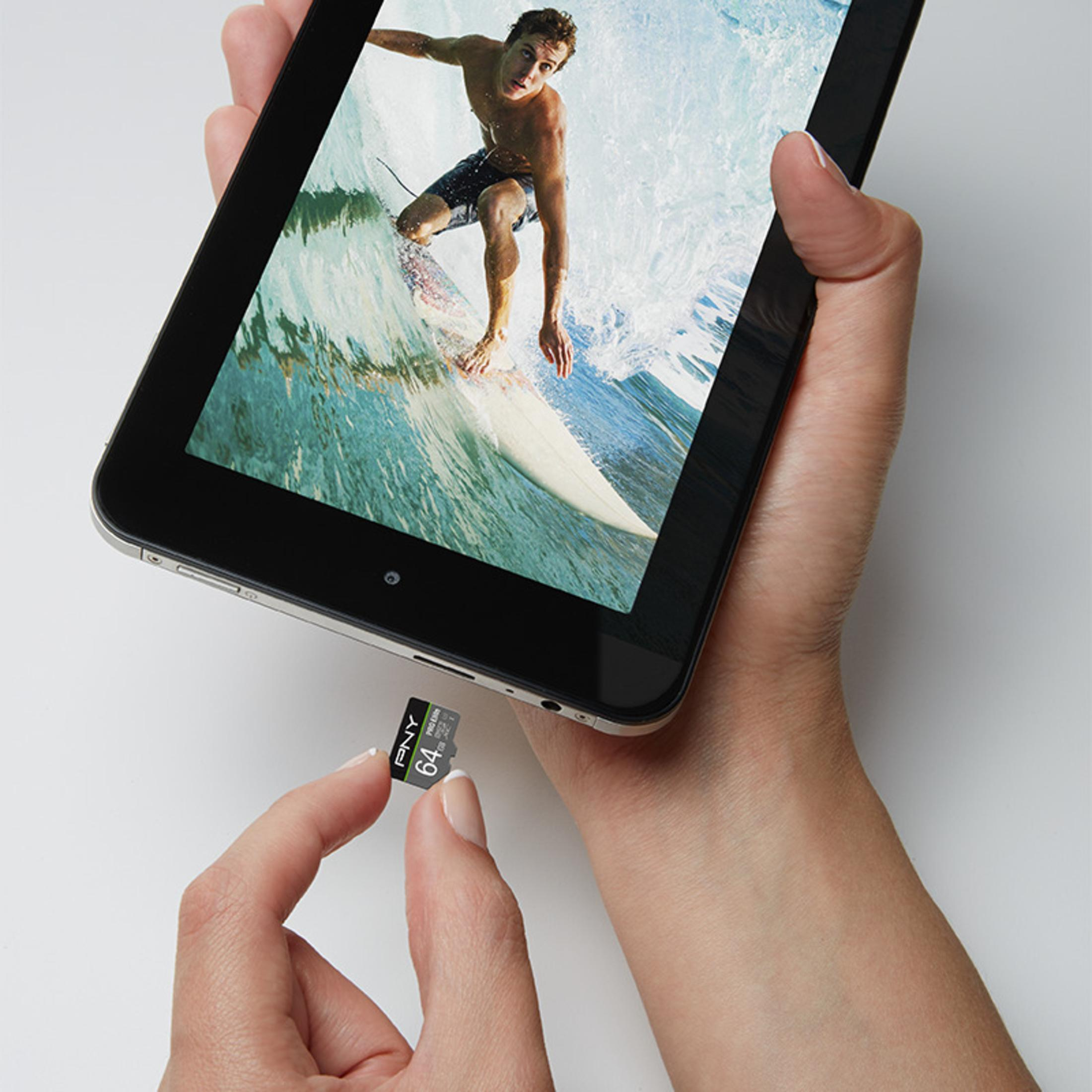 Hände halten ein schwarzes Tablet, das einen Surfer auf einer Welle zeigt. Daneben eine 64 GB SD-Karte.