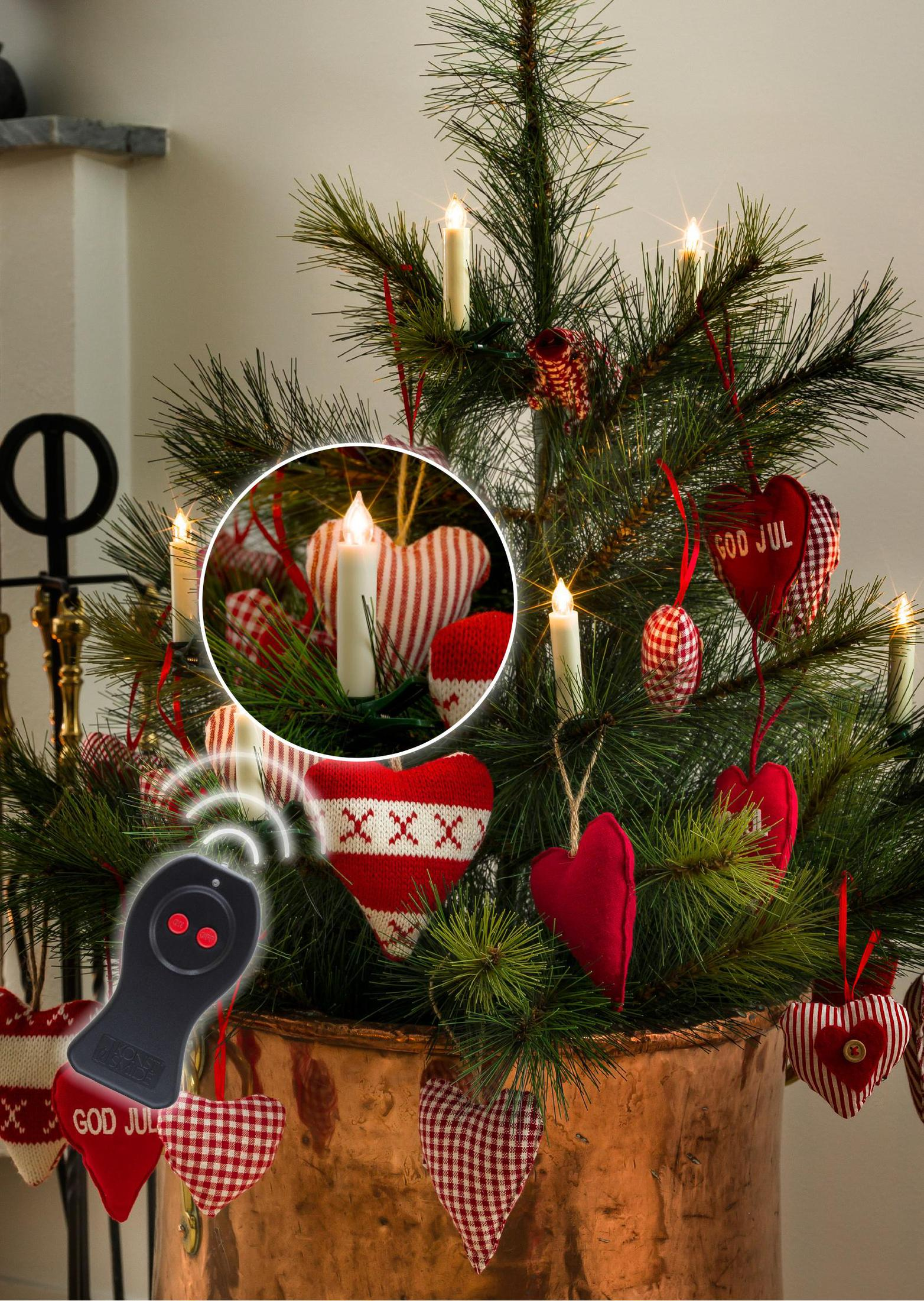 Weihnachtsbaum mit Kerzen, Herzen und Fernbedienung. Nahaufnahme: Kerze und Herz.