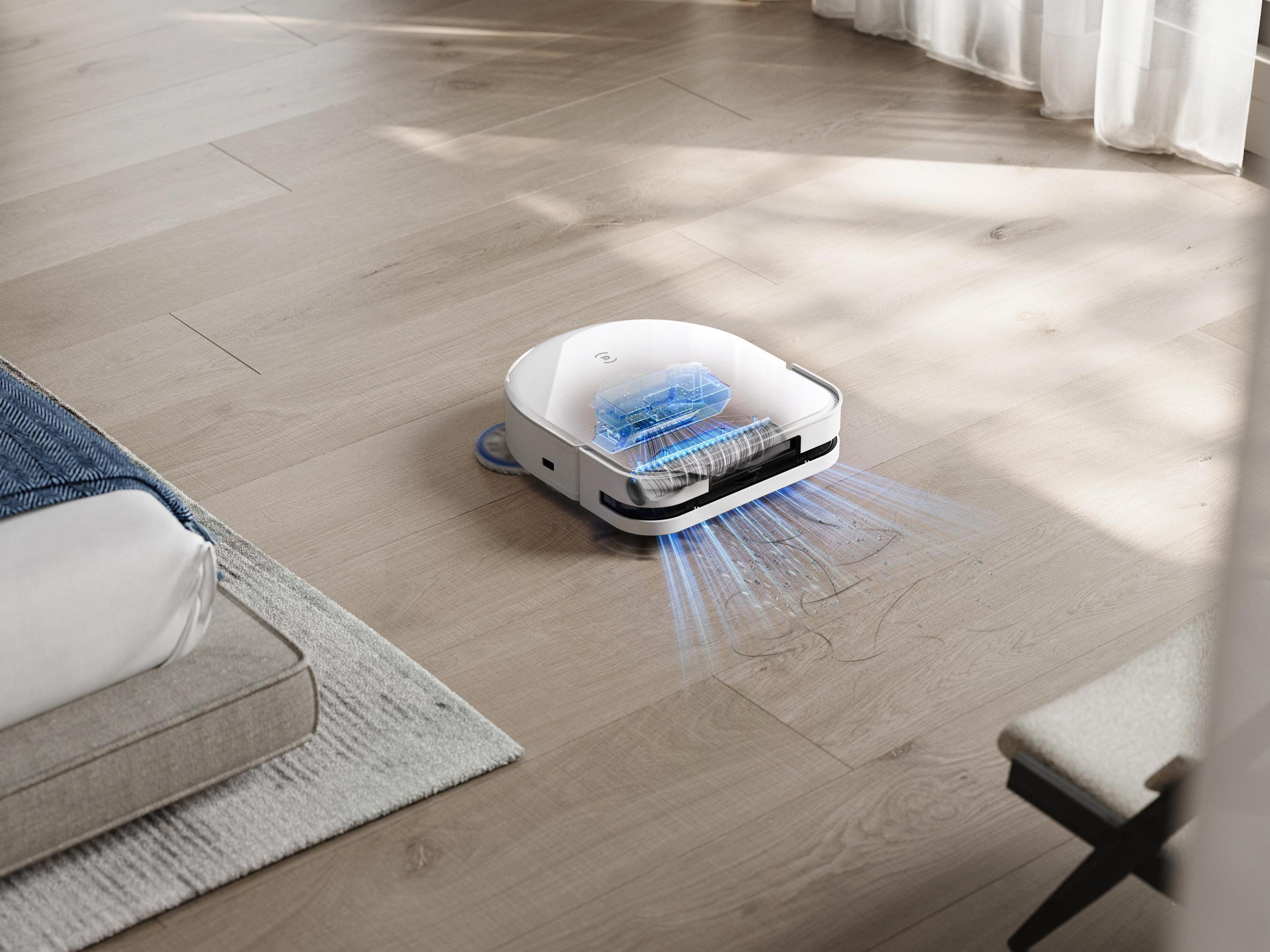 Robot sprzątający na drewnianej podłodze, czyszczenie. Efekt niebieskiego światła.