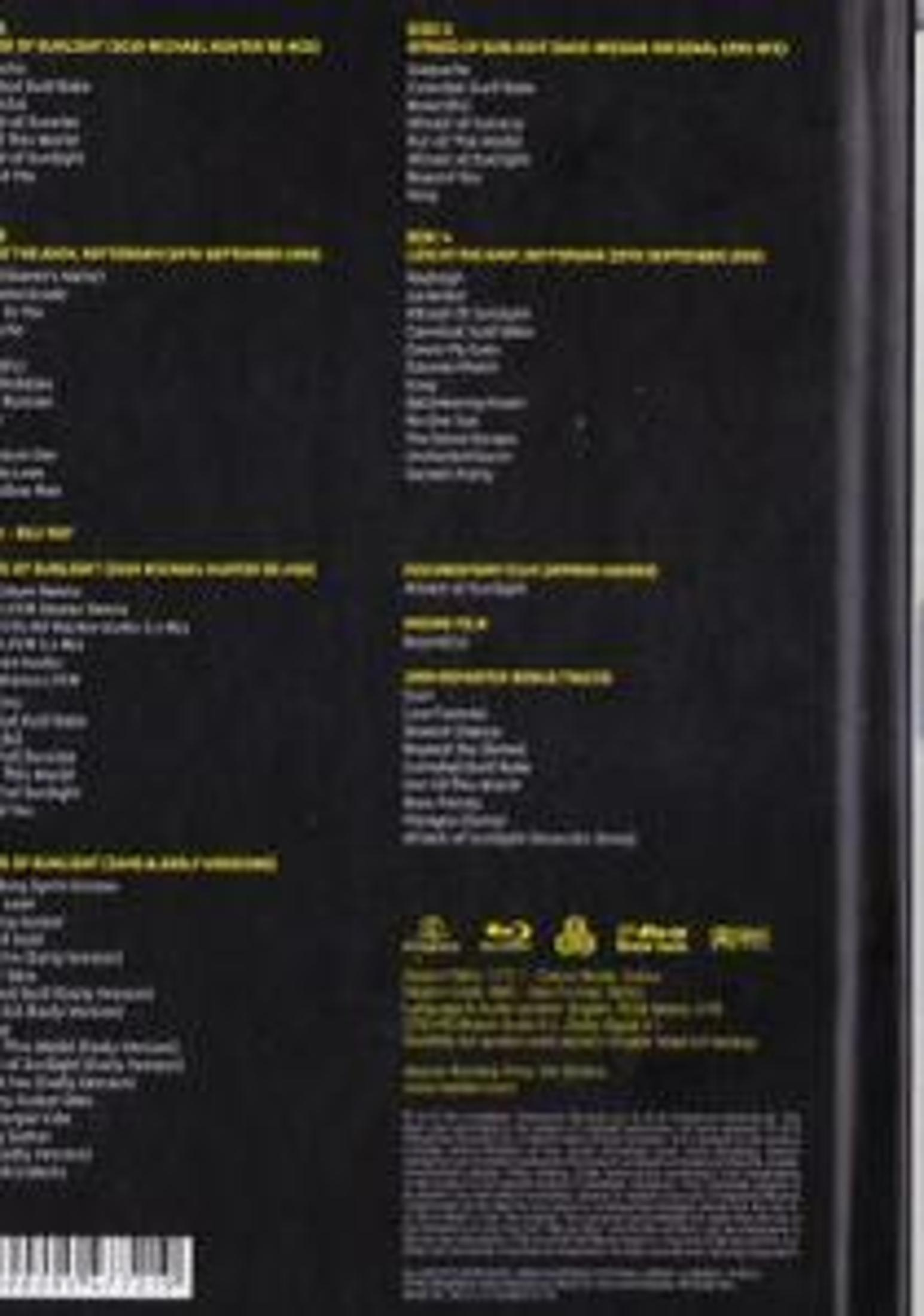 Retro di una scatola nera con testo giallo che elenca i titoli delle canzoni di più dischi.