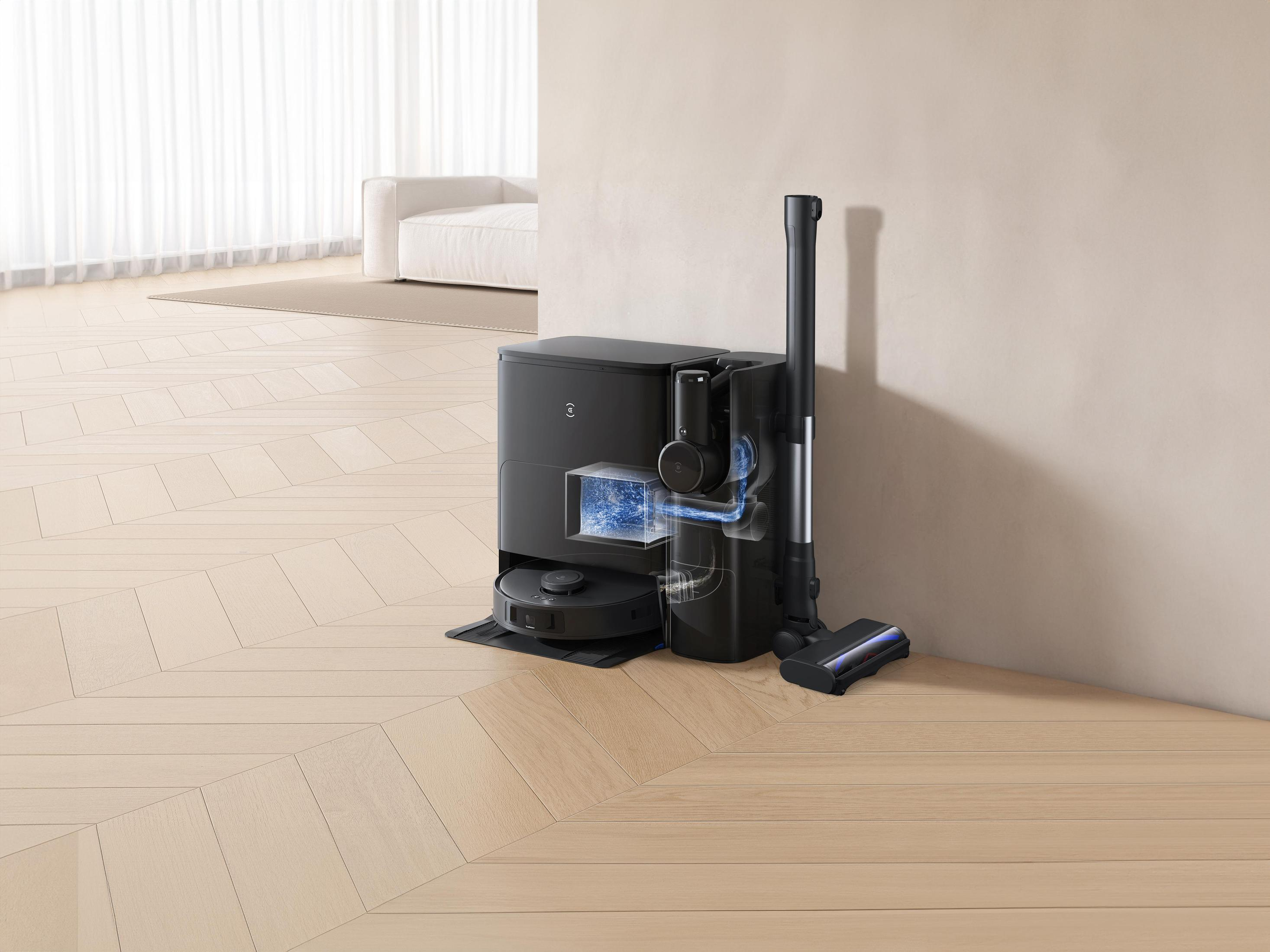 Czarny odkurzacz automatyczny i stacja ładująca na drewnianej podłodze.