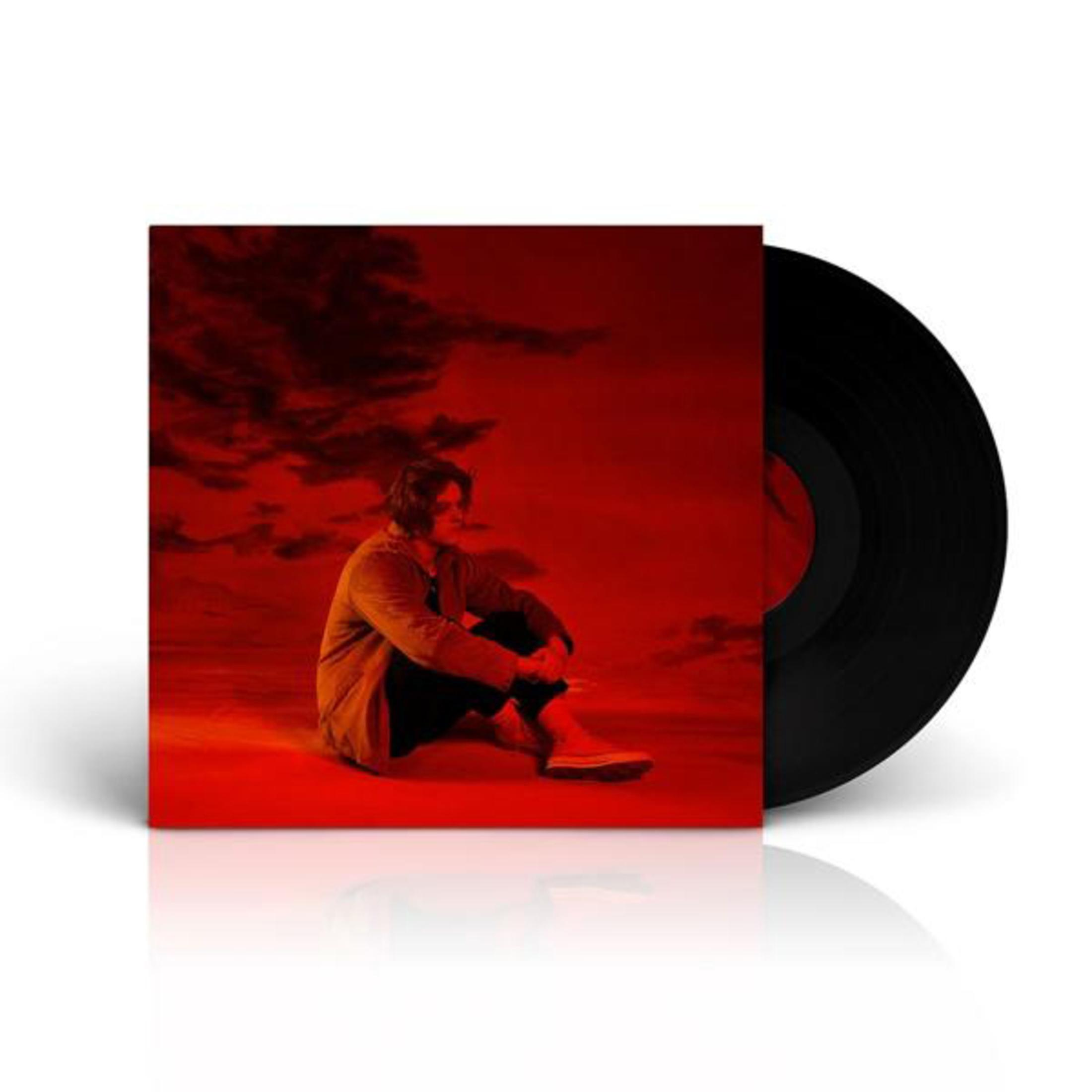 Zittende man, rode achtergrond, albumhoes en vinylplaat.