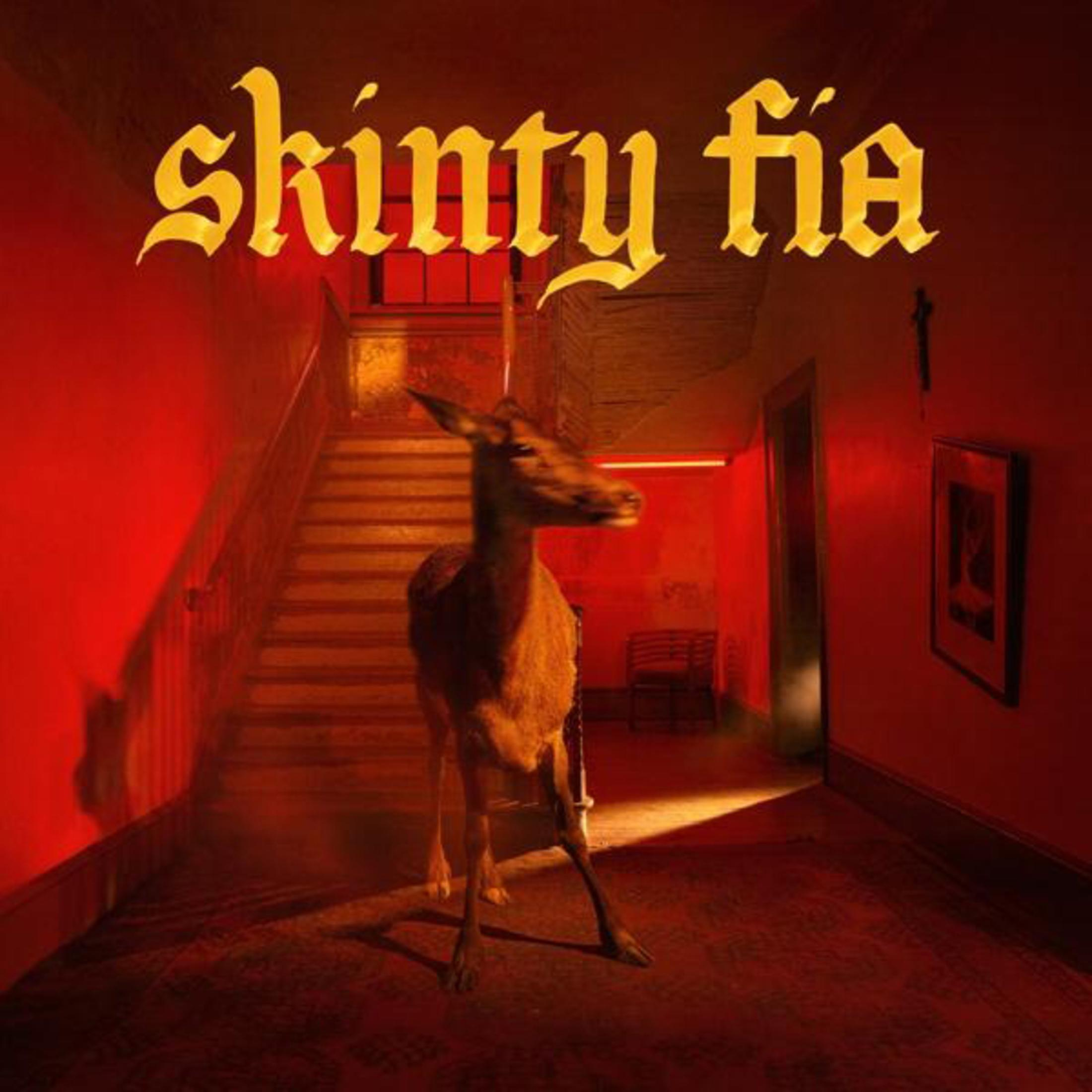 Un cervo è in un corridoio. La parola skinty fia è in alto. Le pareti sono rosse.
