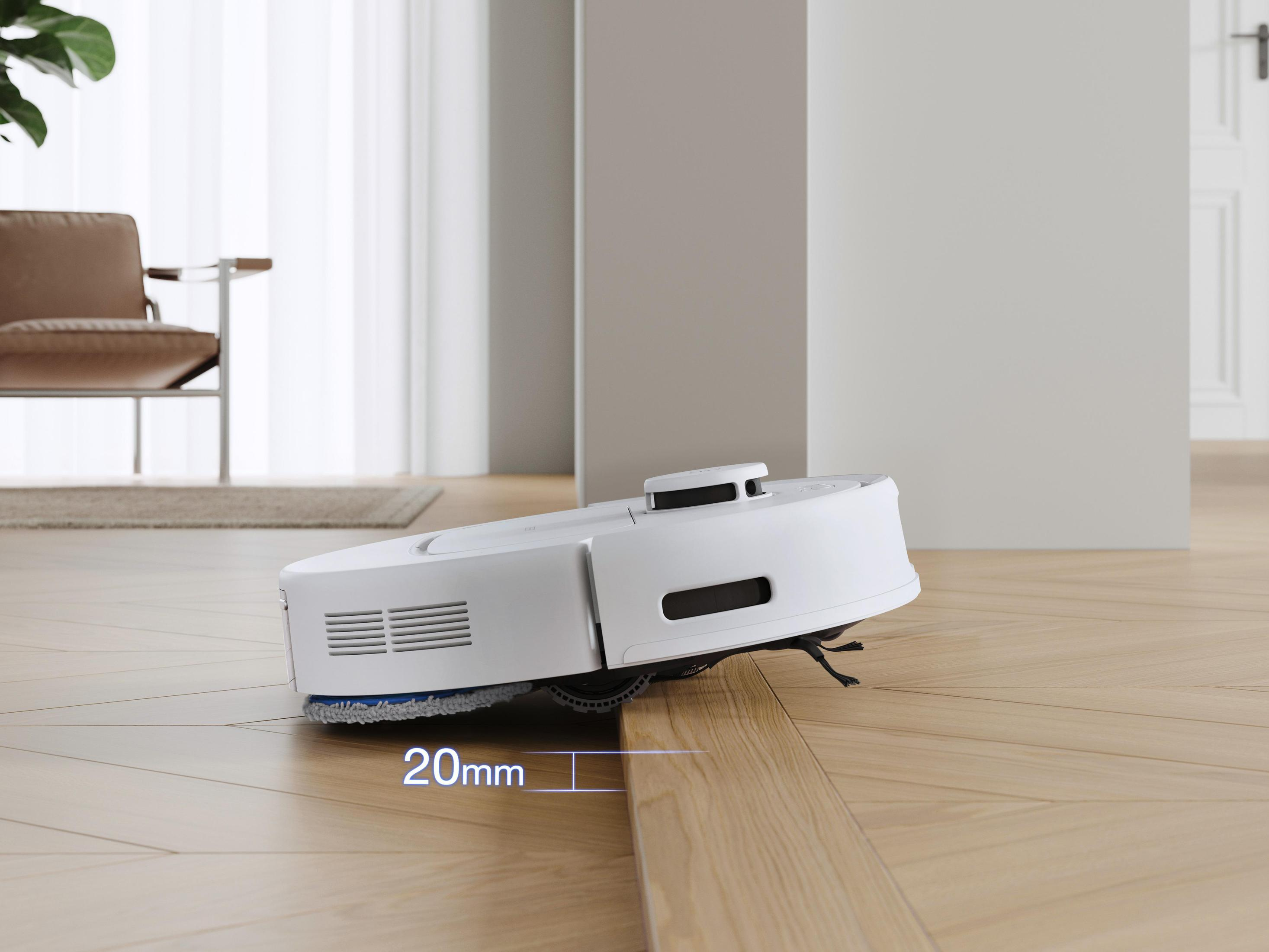 Biały robot odkurzający czyszczący drewnianą podłogę. Na podłodze widoczna jest linia 20 mm.