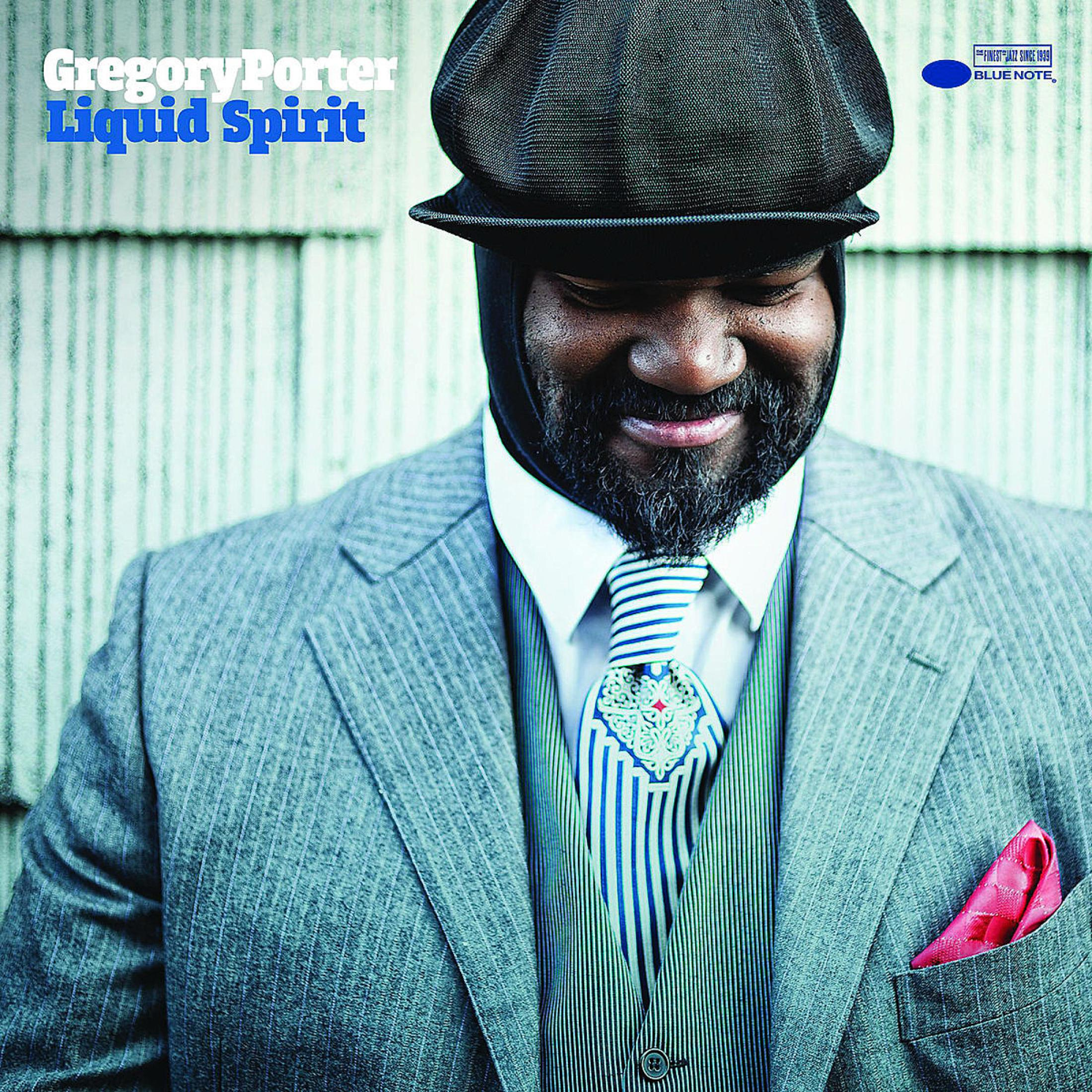 Gregory Porter in giacca e cravatta, che guarda in basso, con un cappello. Il titolo dell'album è "Liquid Spirit".