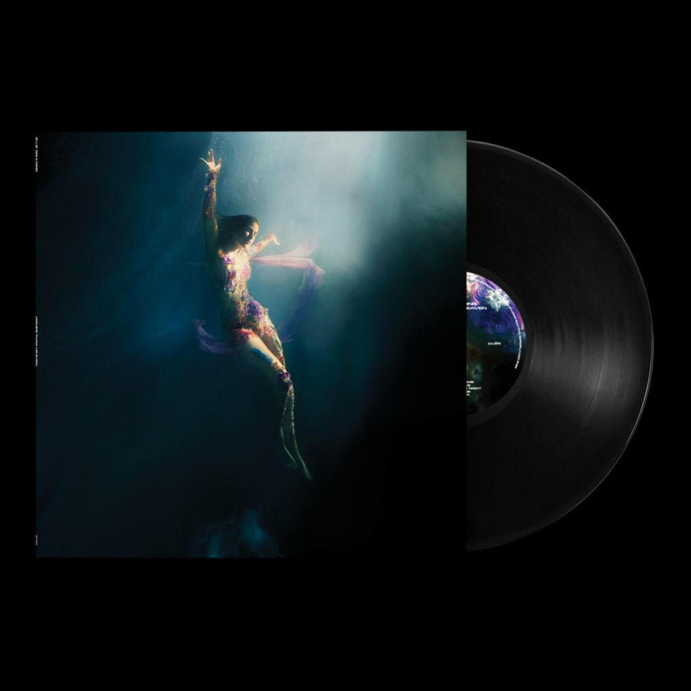A person in a dress underwater next to a record.