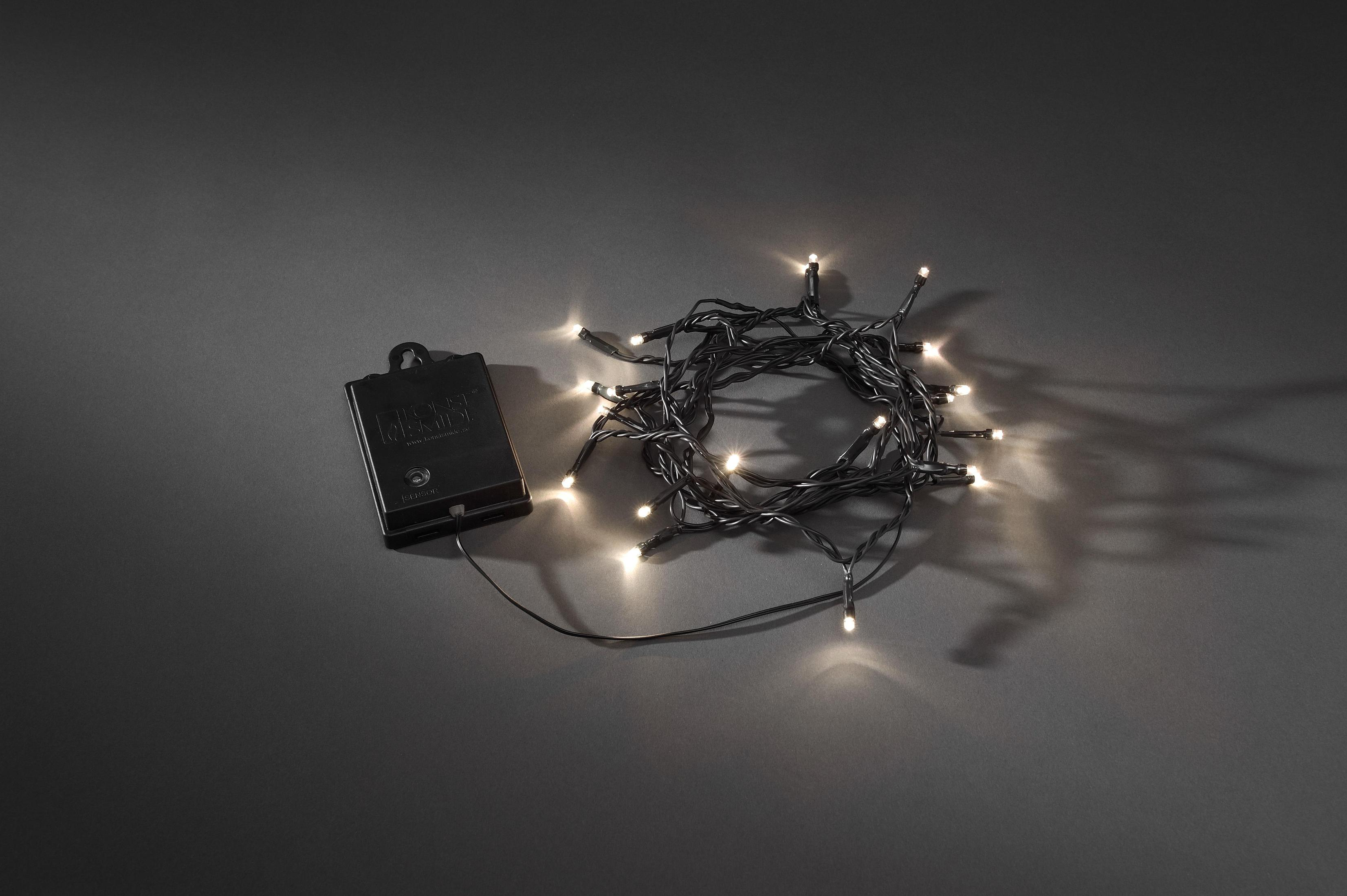 Eine Lichterkette und ein Akku-Pack auf dunkler grauem Untergrund.